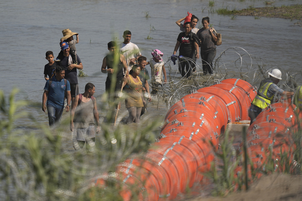 Migrants face barbed wire in the Rio Grande river