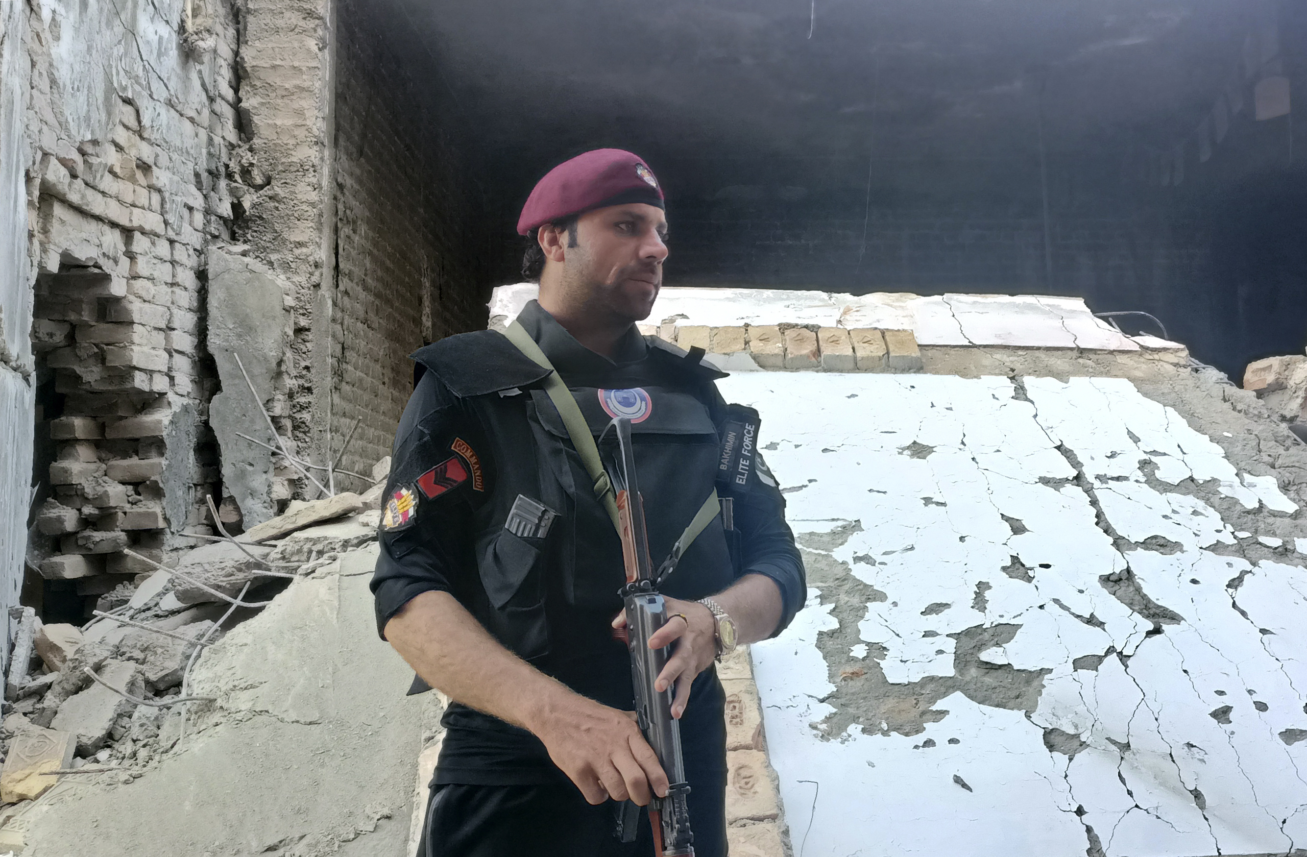A security member stands guard inside a damages police compound after a suicide bomber attack in the Bara Khyber Pakhtunkhwa, Pakistan, Thursday, July 20, 2023