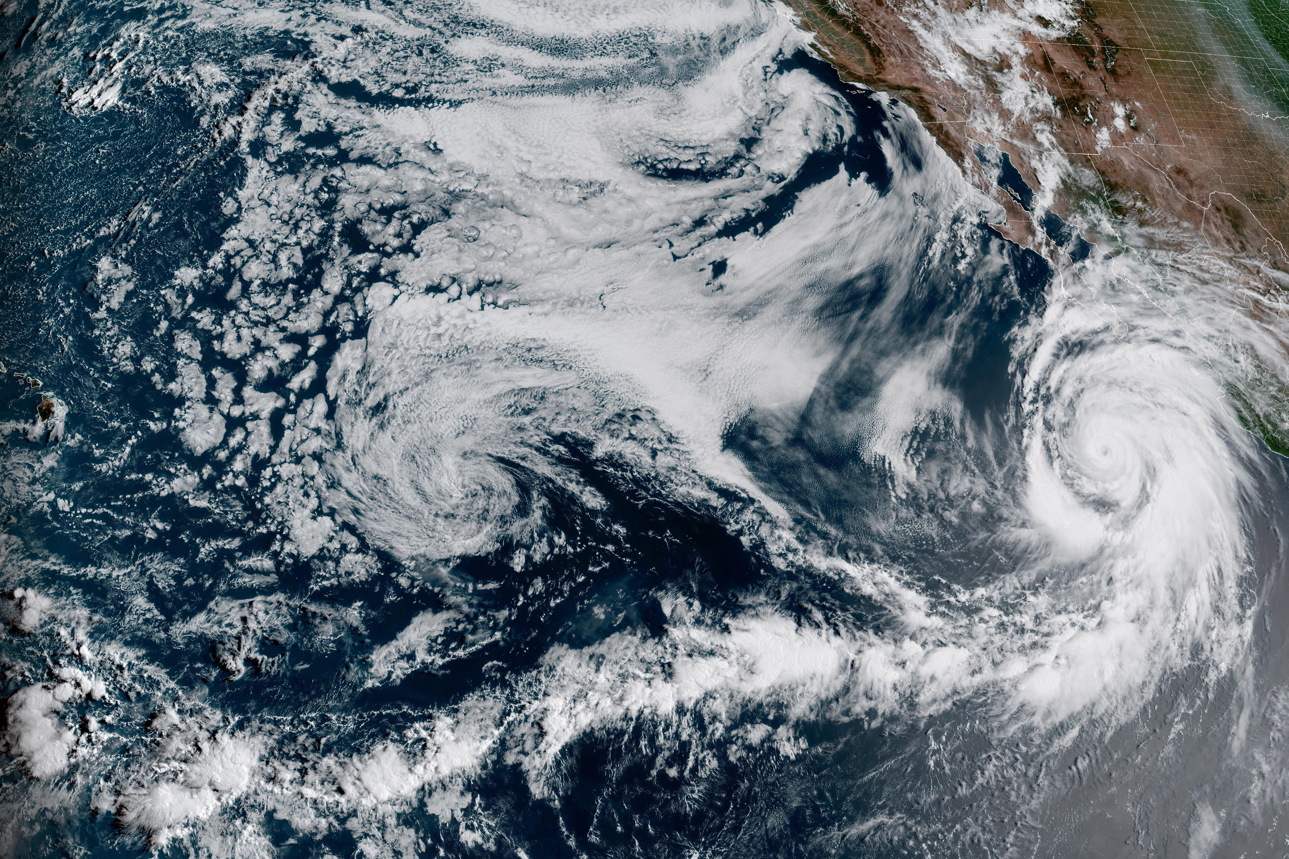 This Friday, Aug. 18, 2023, 1:10 p.m. EDT satellite image provided by the National Oceanic and Atmospheric Administration shows Hurricane Hilary, right, off Mexico’s Pacific coast. Swirls of cloud float off the Baha California peninsula.