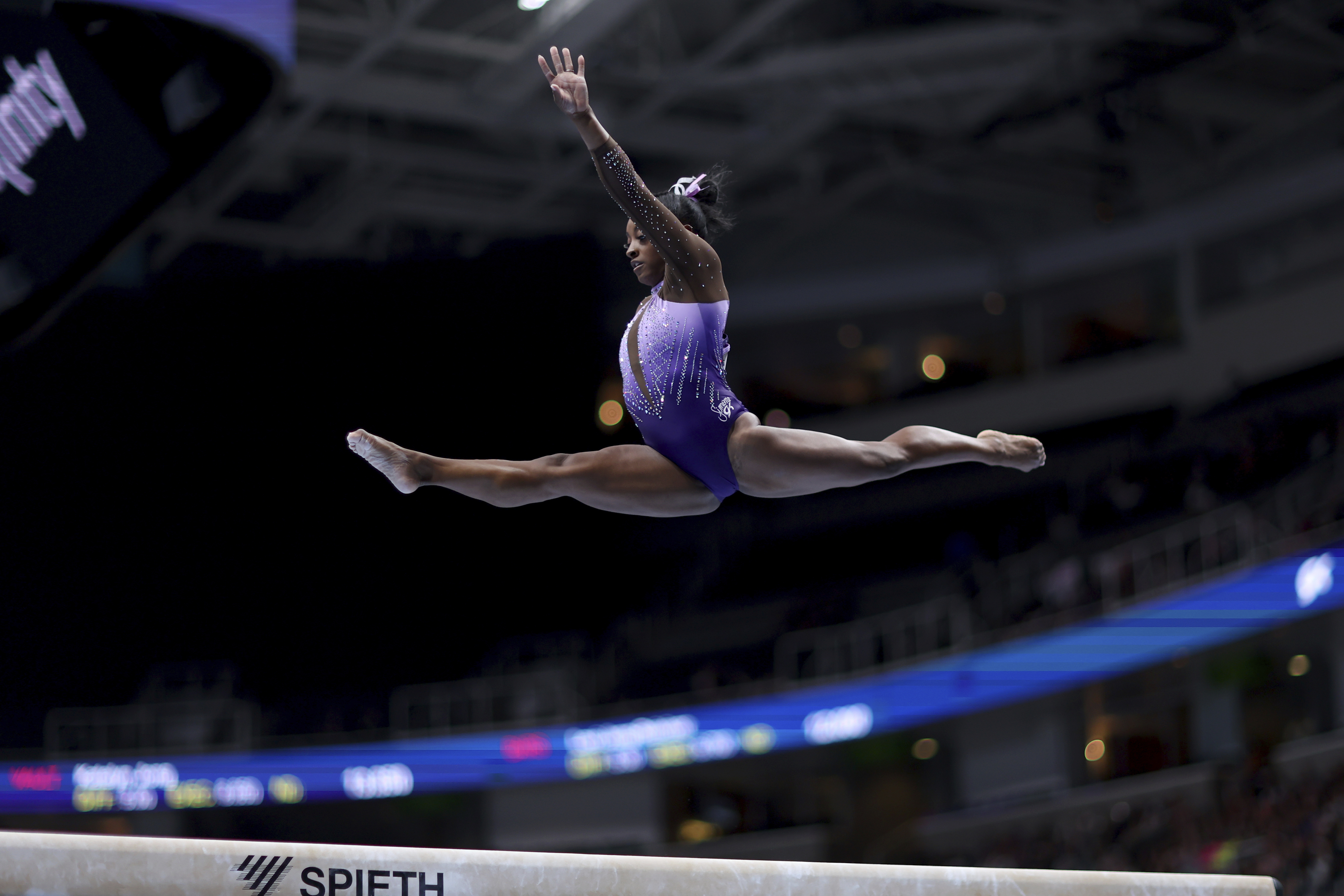 Simone Biles competing on the balance beam. 
