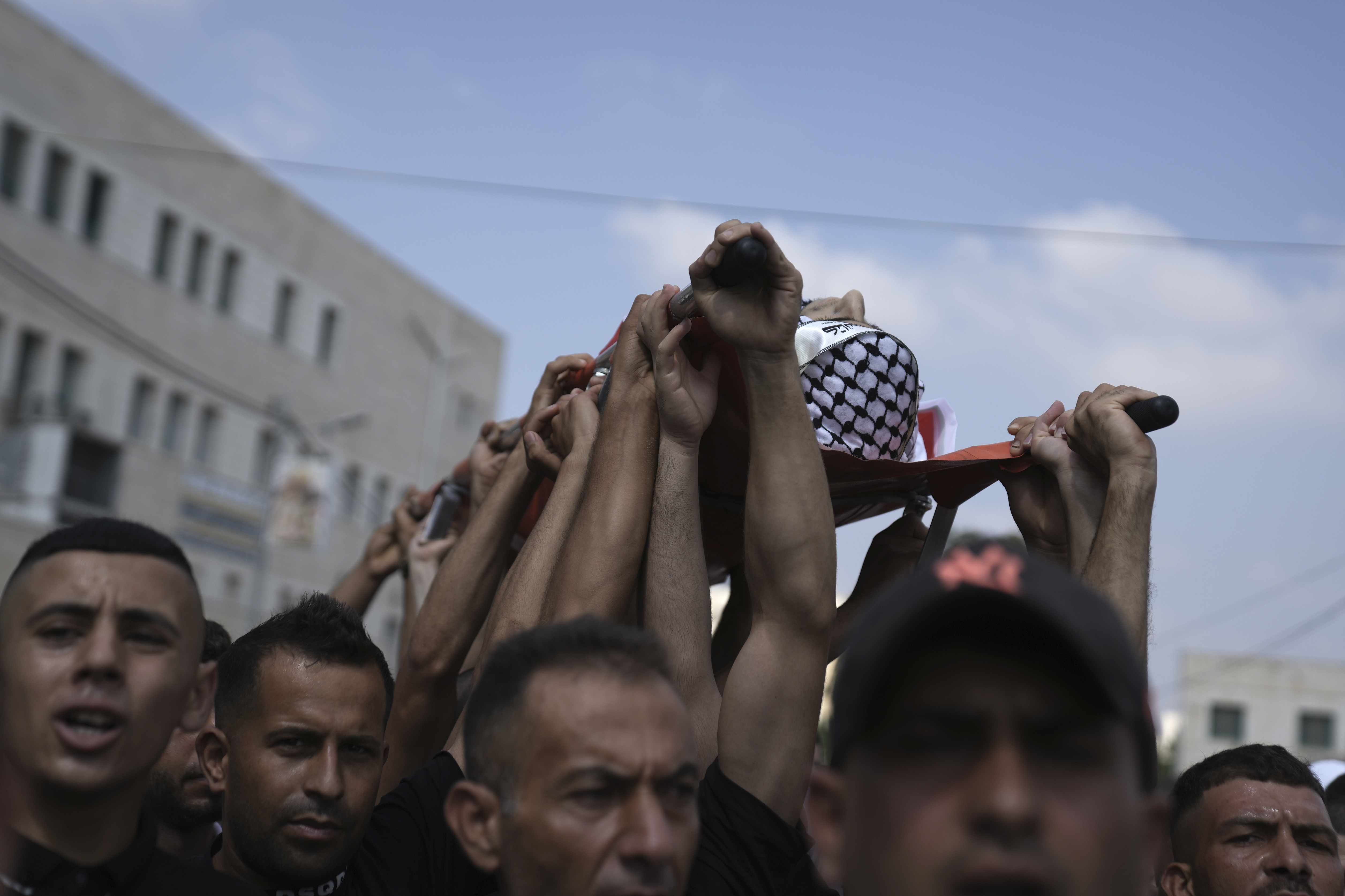 Palestinian mourners carry the body of Ezzedin Kanan, 20, who succumbed to his wounds sustained during an Israeli army operation last month, during his funeral in the West Bank city of Jenin, Saturday, Aug. 26, 2023. The July 3 raid was the most intense Israeli military operation in years in the West Bank, involving airstrikes and hundreds of ground troops, that left a wide swath of damage in its wake. Kanan's death brings the death toll in the raid to 13. (AP Photo/Nasser Nasser)