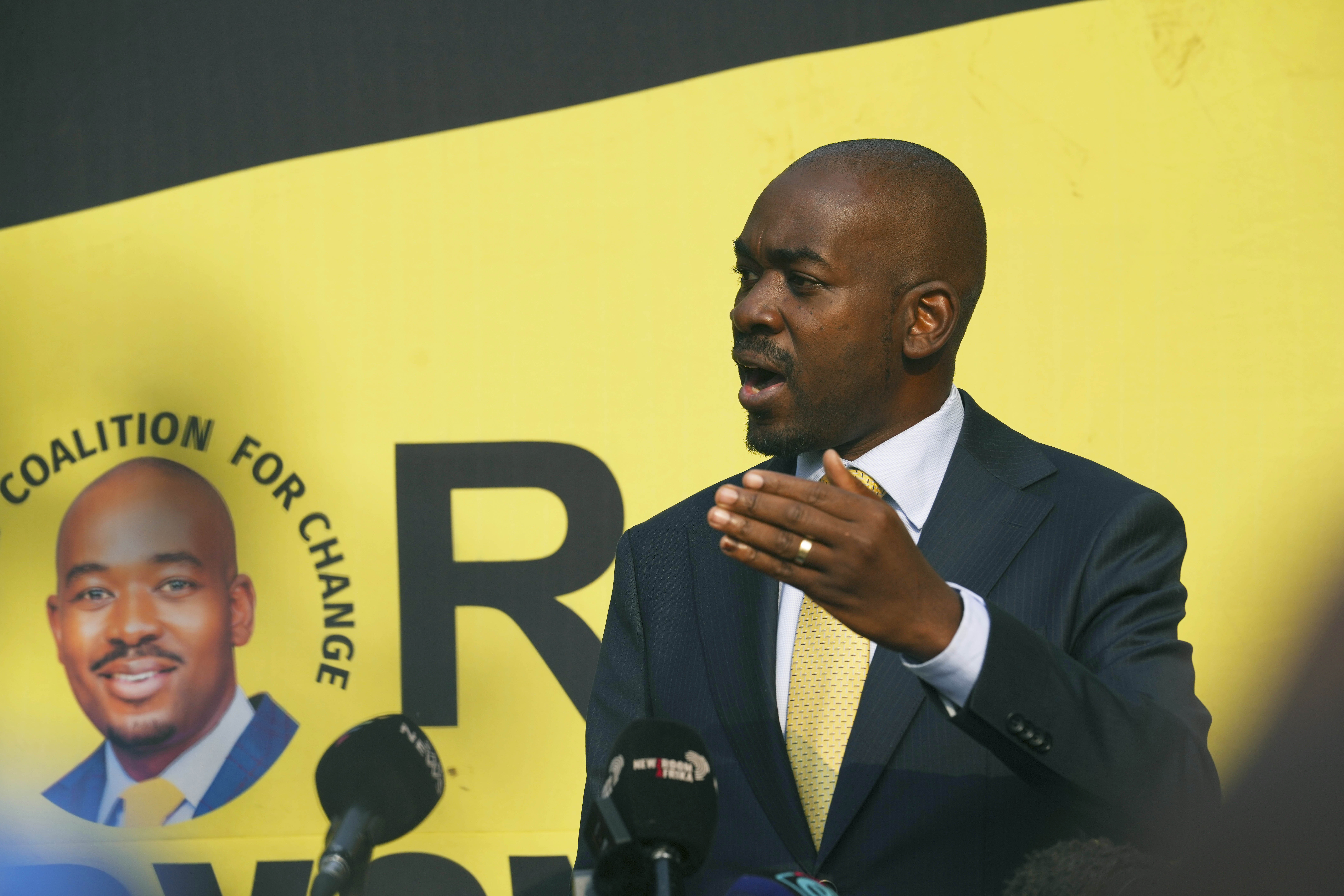 Zimbabwe opposition leader Nelson Chamisa speaking at a press conference in Harare. He is making a point with his left hand, and standing on front of a yellow backdrop.