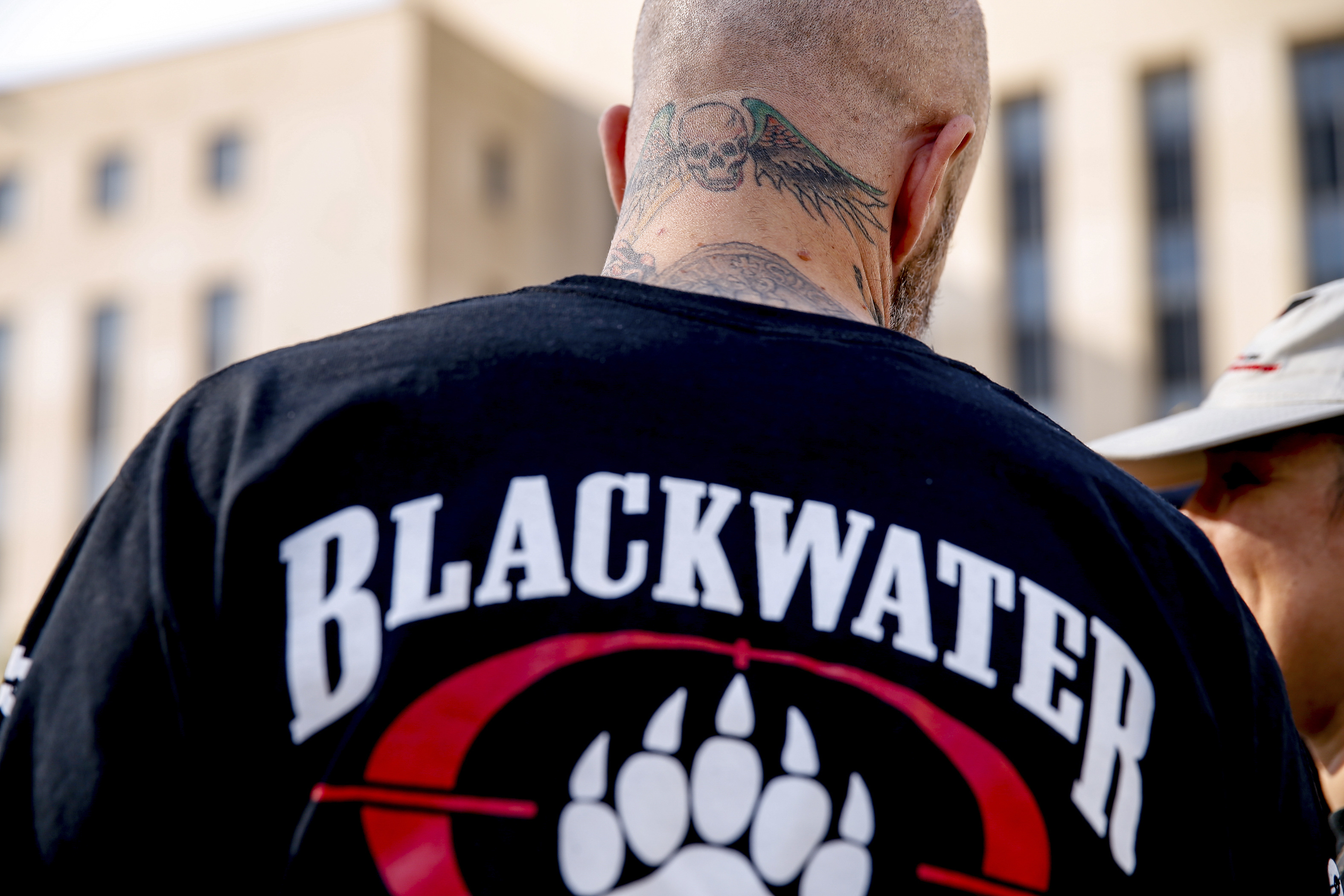 A former member of Blackwater joines family members, friends, and supporters of four former Blackwater security guards outside the federal court in Washington, Monday, April 13, 2015, following sentencing for four former Blackwater security guards in connection with a 2007 shooting of civilians in Iraq. U.S. District Judge Royce Lamberth sentenced Nicholas Slatten to life in prison while Paul Slough of Keller, Texas, Evan Liberty of Rochester, N.H., and Dustin Heard of Knoxville, Tenn., were convicted of manslaughter and received sentences of 30 years plus one day. (AP Photo/Andrew Harnik)