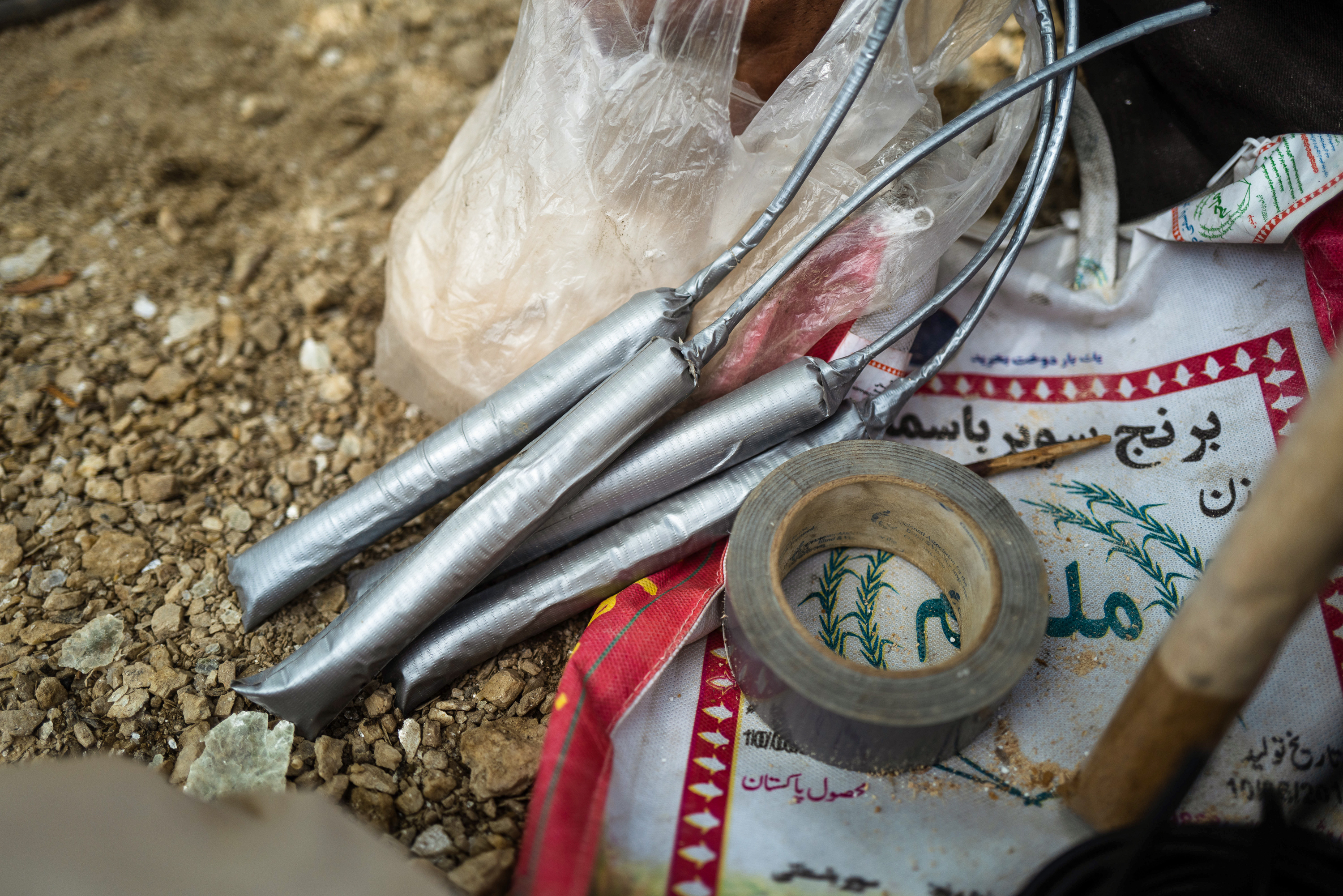 The men at the mine make dynamite by hand, mixing the ingredients inside plastic sleeves before inserting a fuse and wrapping the sticks in tape.