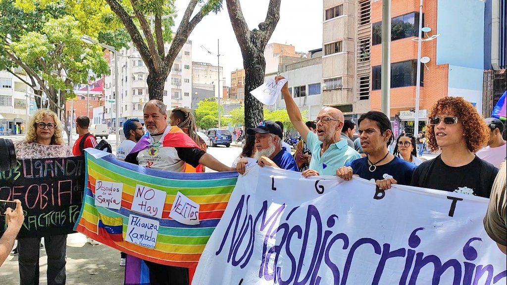 People line up behind long banners that read, "No More Discrimination!" or bear the rainbow flag.