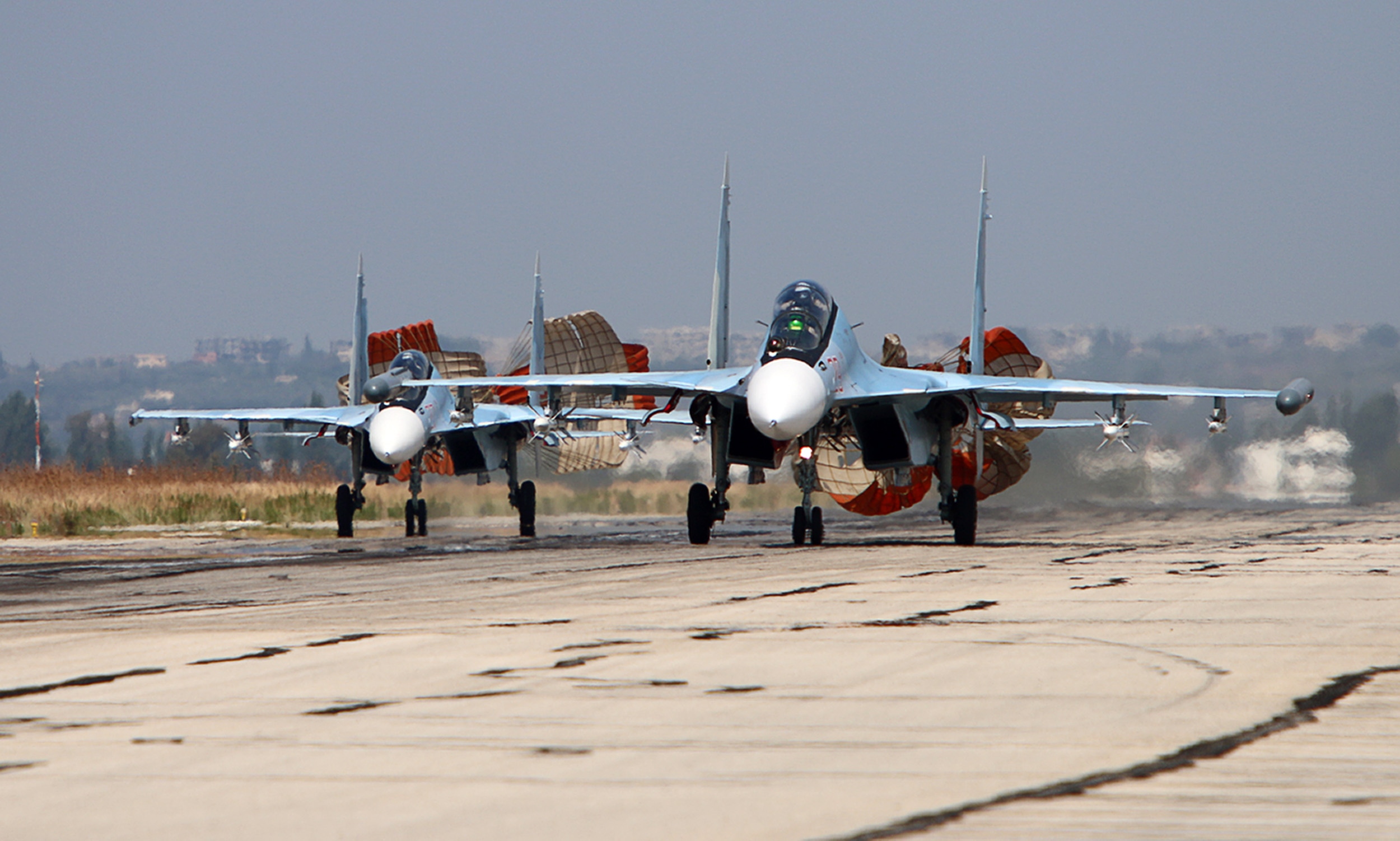 A picture taken on October 3, 2015 shows Russian Sukhoi Su-30 SM jet fighters landing on a runway at the Hmeimim airbase in the Syrian province of Latakia. AFP PHOTO / KOMSOMOLSKAYA PRAVDA / ALEXANDER KOTS *RUSSIA OUT* (Photo by ALEXANDER KOTS / KOMSOMOLSKAYA PRAVDA / AFP) / RUSSIA OUT