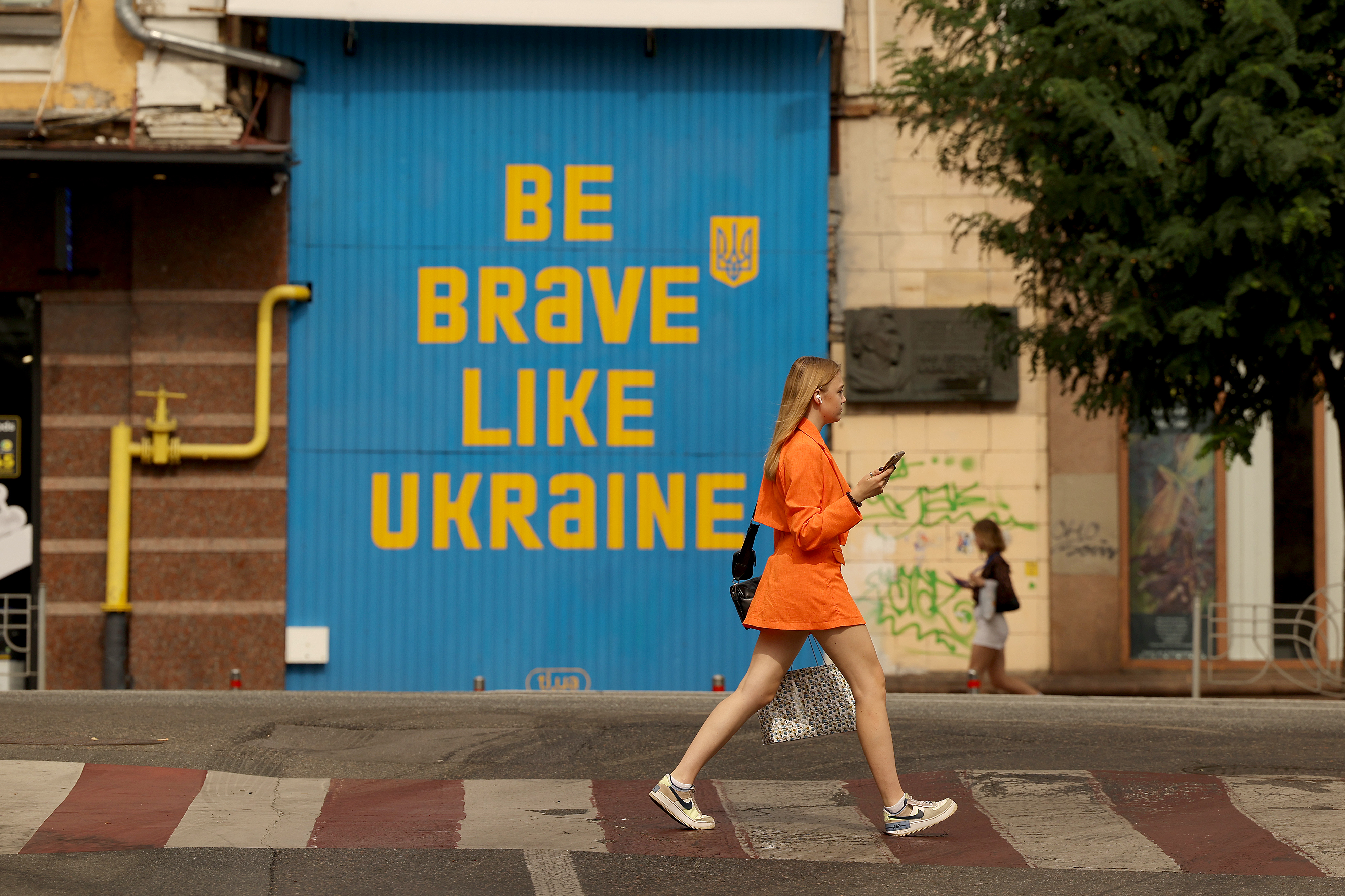 epa10828125 A woman walks past a mural in downtown Kyiv, Ukraine, 30 August 2023. Russian forces attacked Kyiv in the early hours of 30 August 2023, killing two people and injuring another, Kyiv City Military Administration Head Serhii Popko reported. EPA-EFE/CATHAL MCNAUGHTON