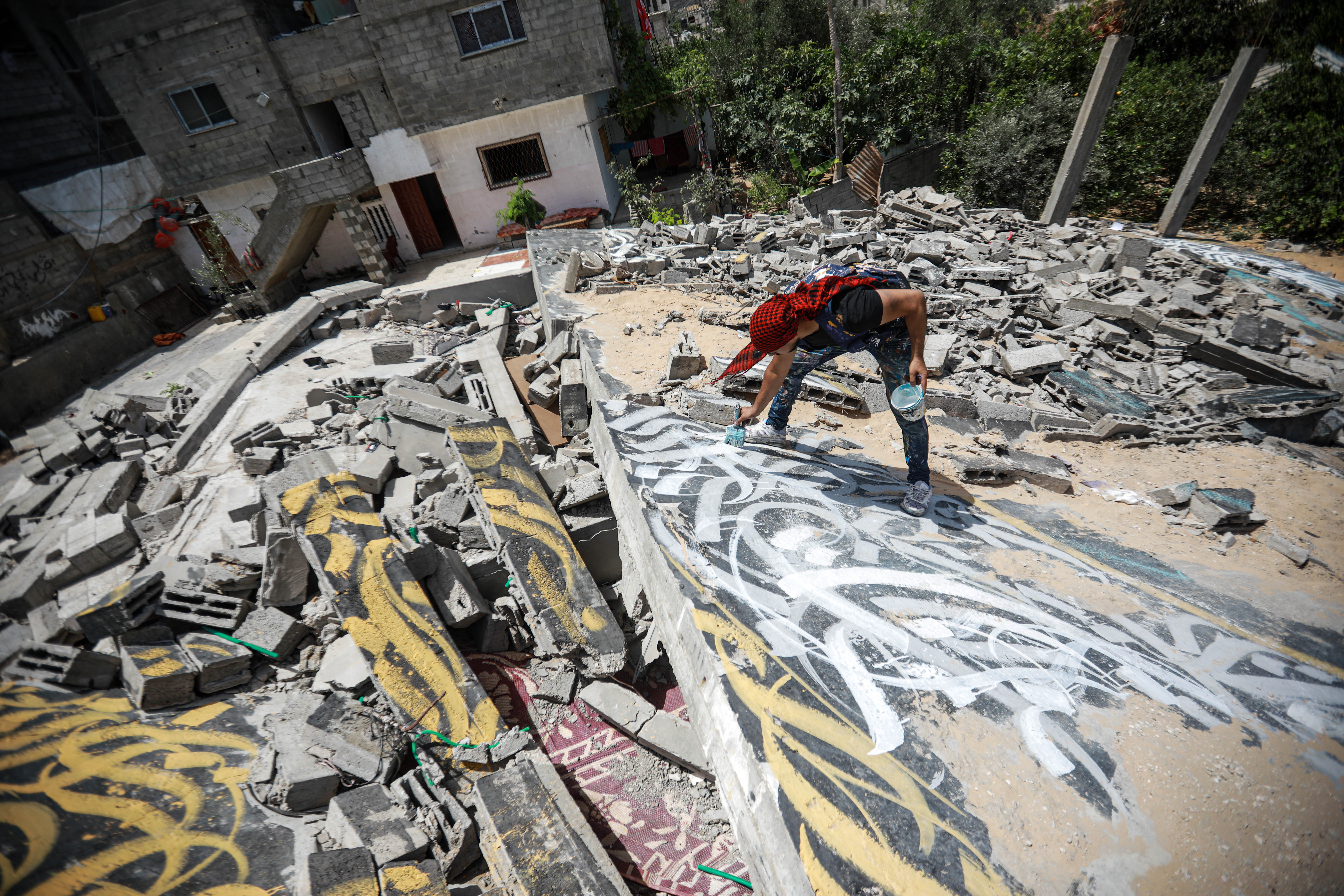 Ayman outdoors on some rubble painting