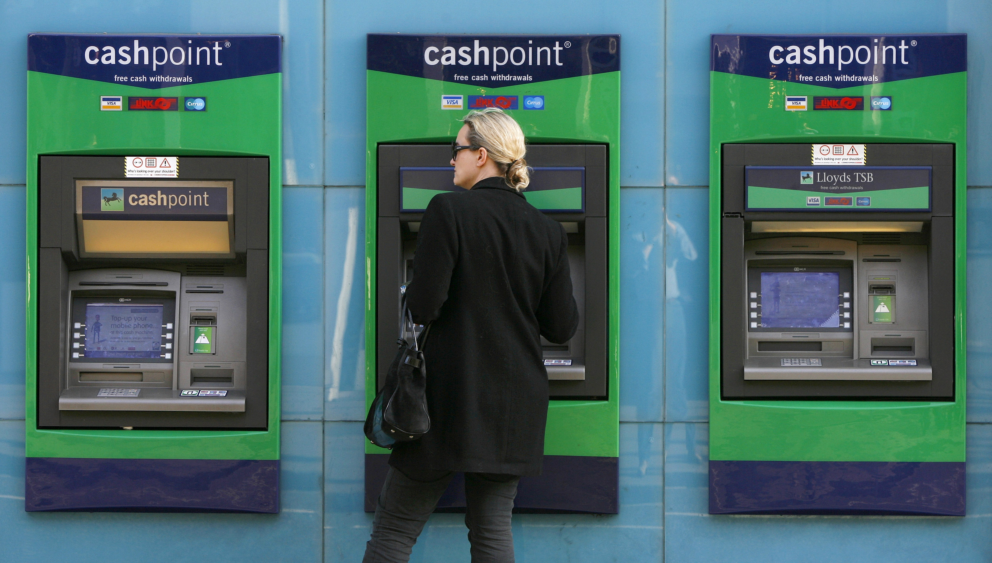 A woman uses a Lloyds ATM machine in Chelsea, west London February 27, 2009