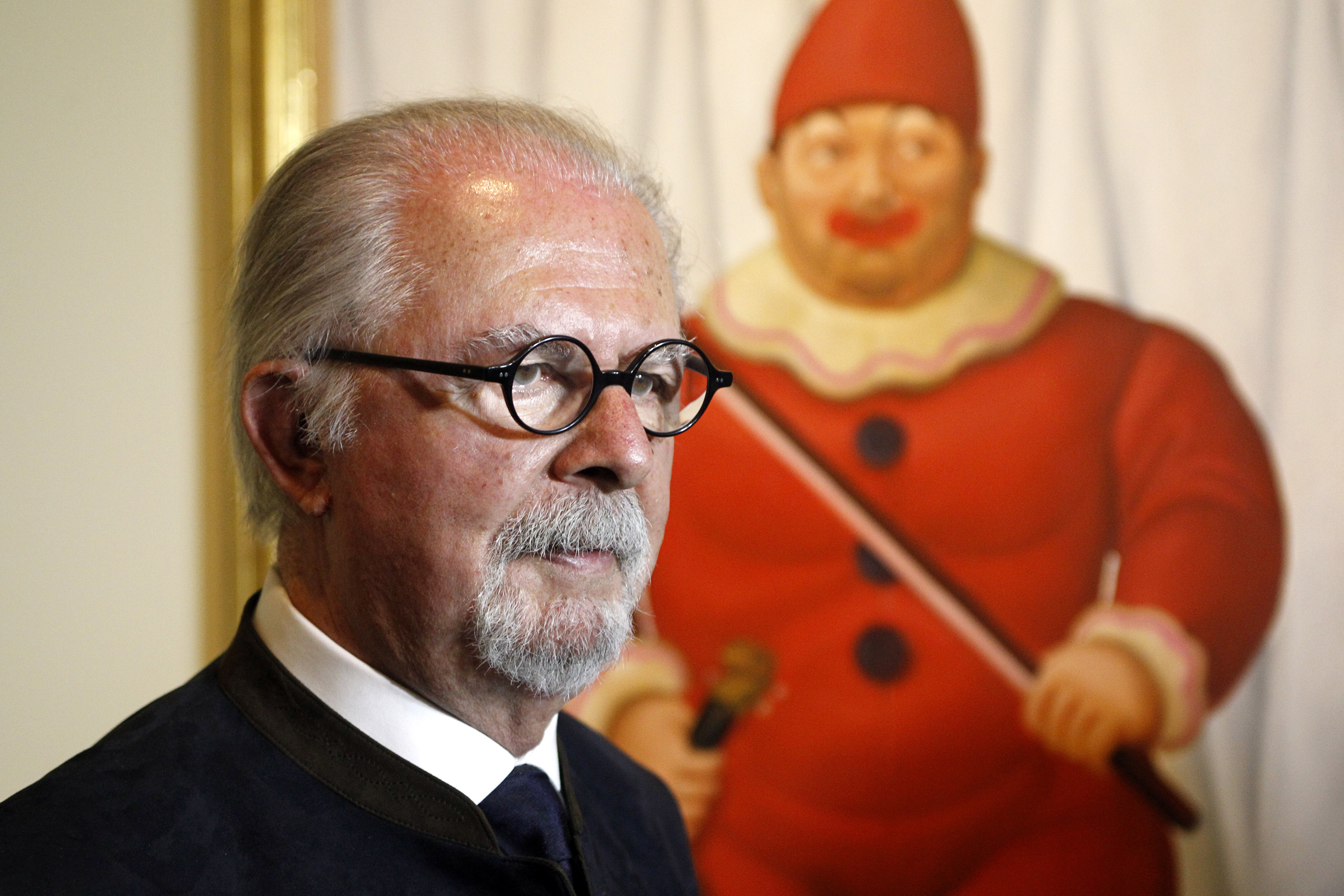 Colombian artist Fernando Botero poses in front of one of his paintings