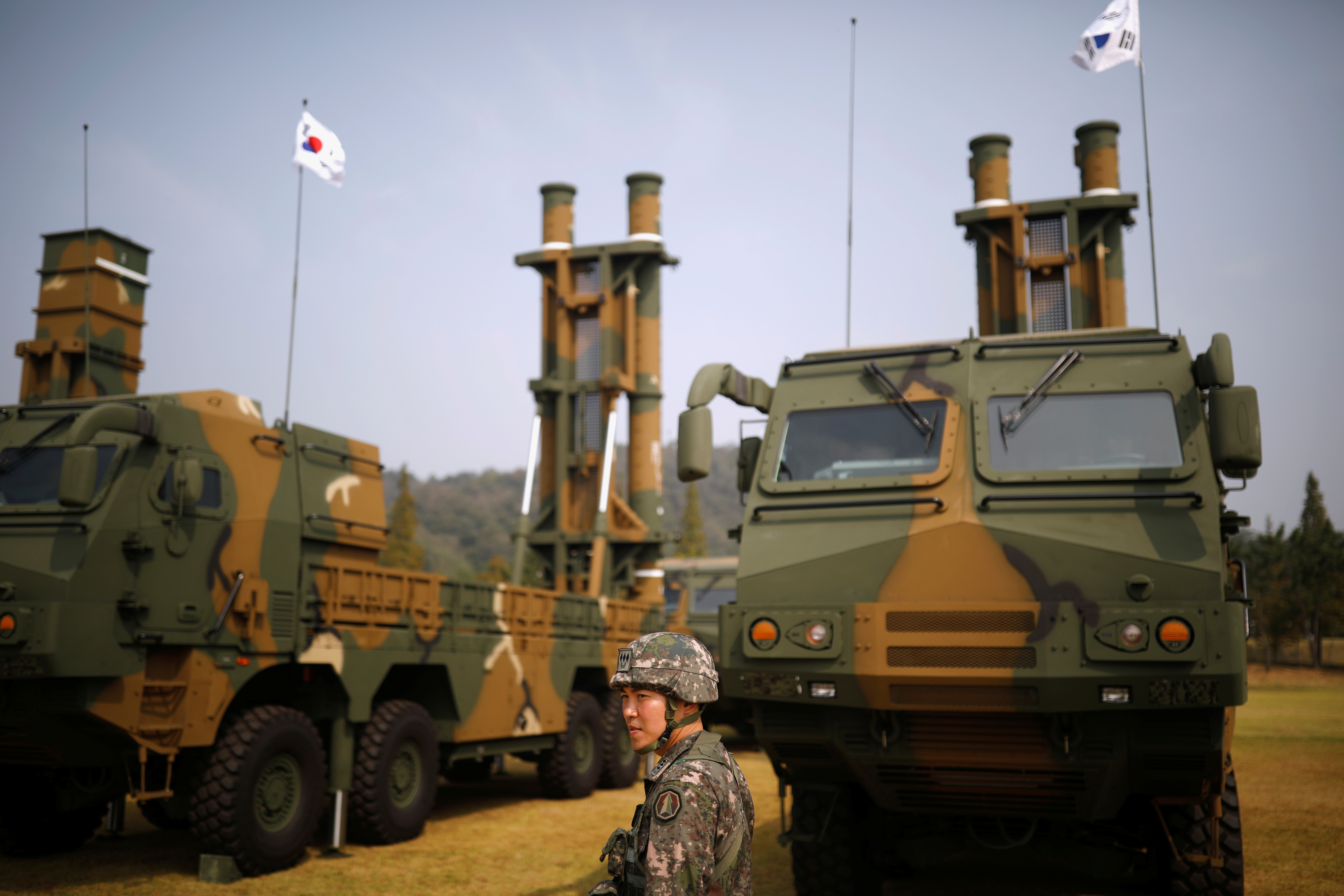 Hyunmoo-2 and Hyunmoo-3 ballistic missiles on display at a previous Armed Forces Day event. A soldier is in front and South Korean flags are flying.