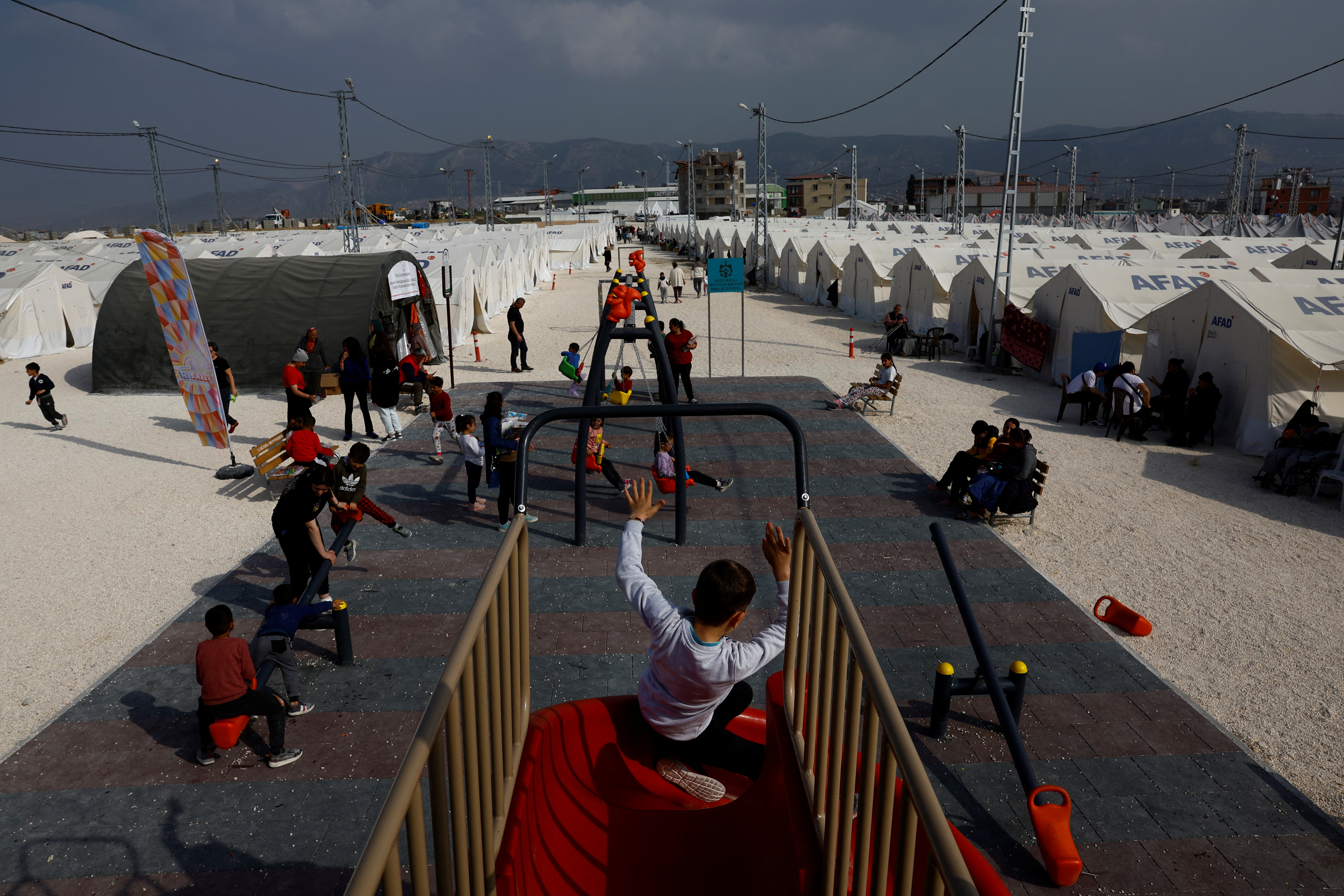 Children play at a playground in Orhanli tent city in the aftermath of a deadly earthquake, in Antakya, Hatay province, Turkey, March 3, 2023