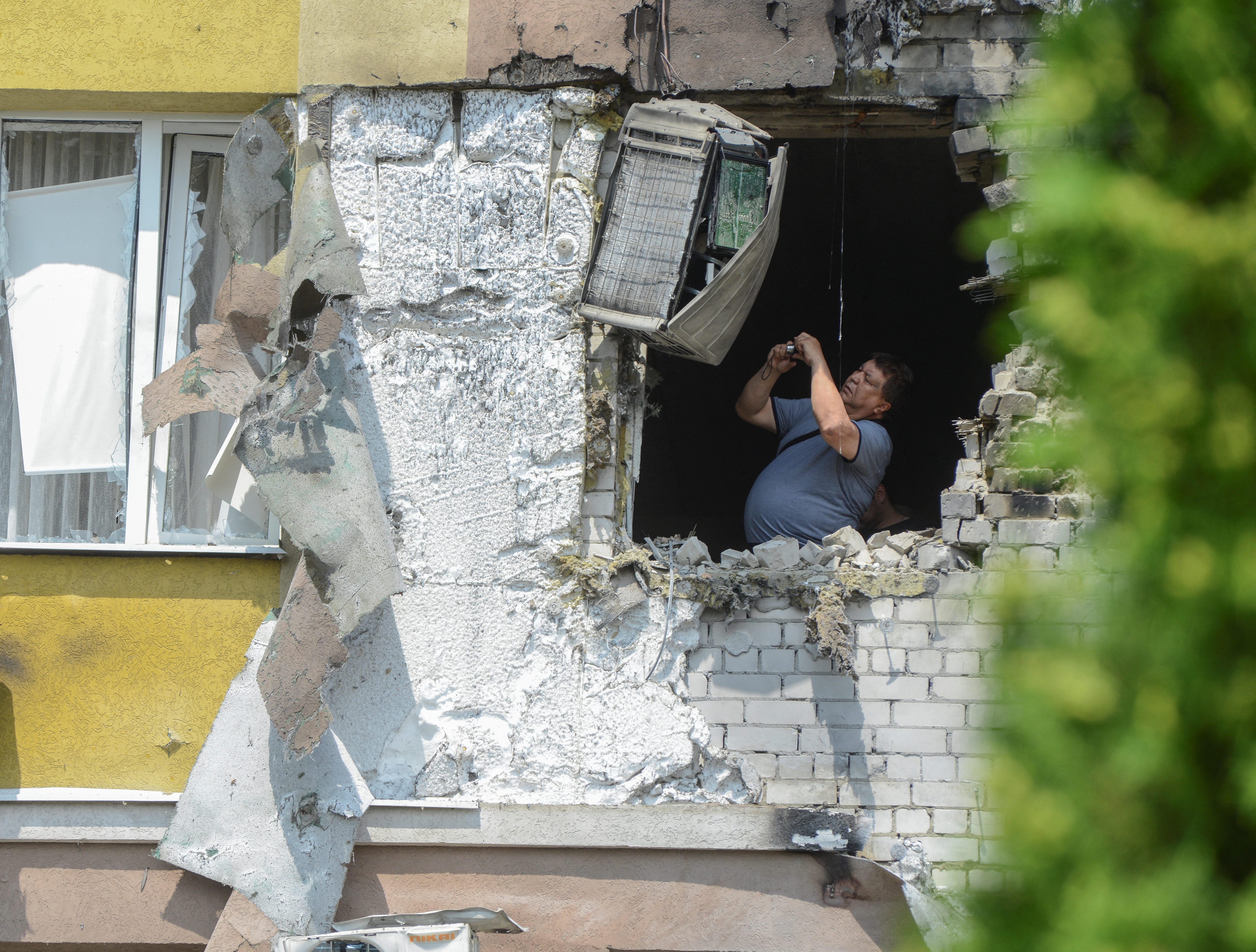 A man takes pictures inside a damaged multi-storey apartment block following a reported drone attack in Voronezh, Russia June 9, 2023. REUTERS/Vladimir Lavrov
