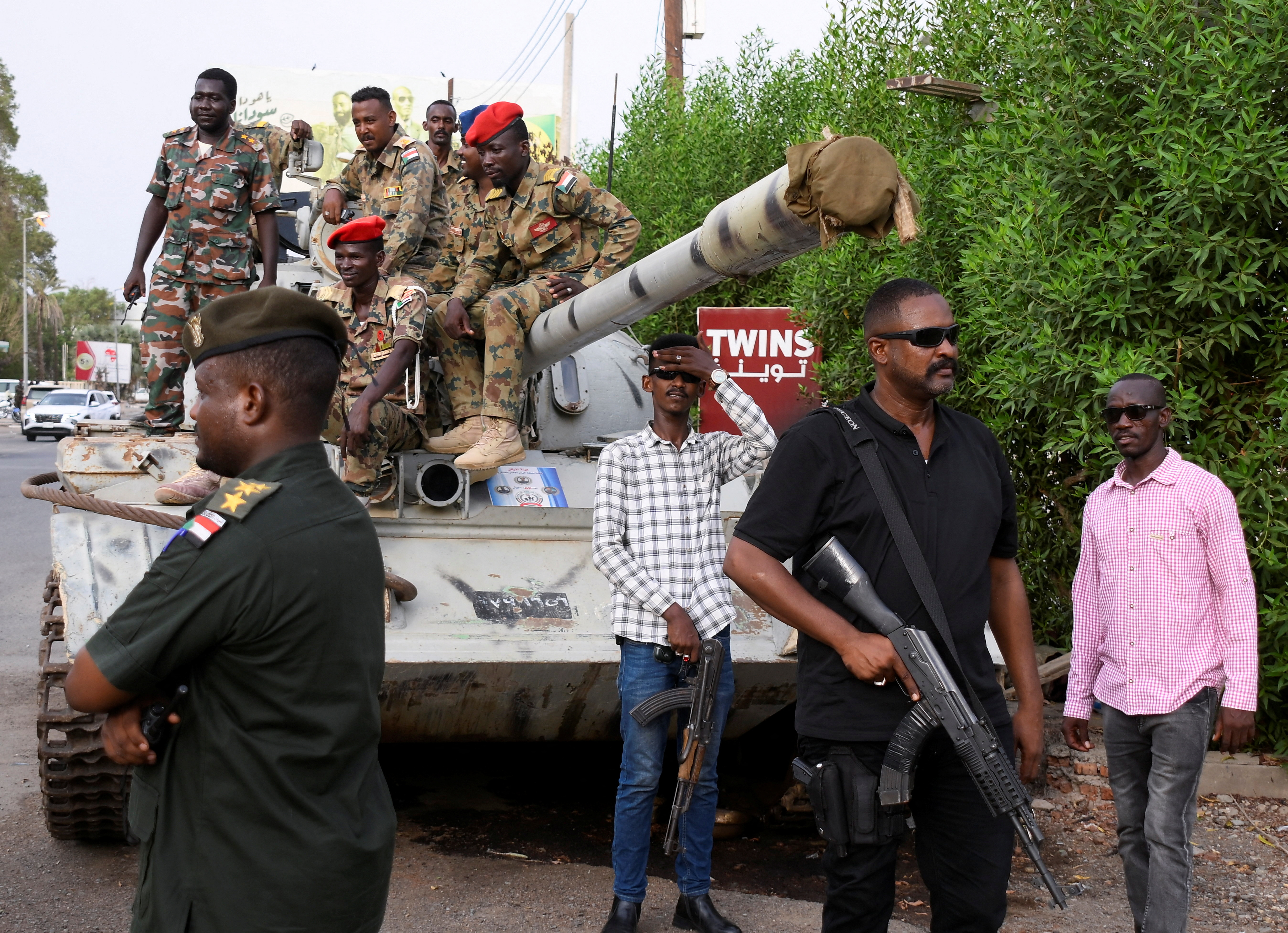 Members of military armed guard and members in plainclothes are seen around a tank after the arrival of Sudan's General Abdel Fattah al-Burhan