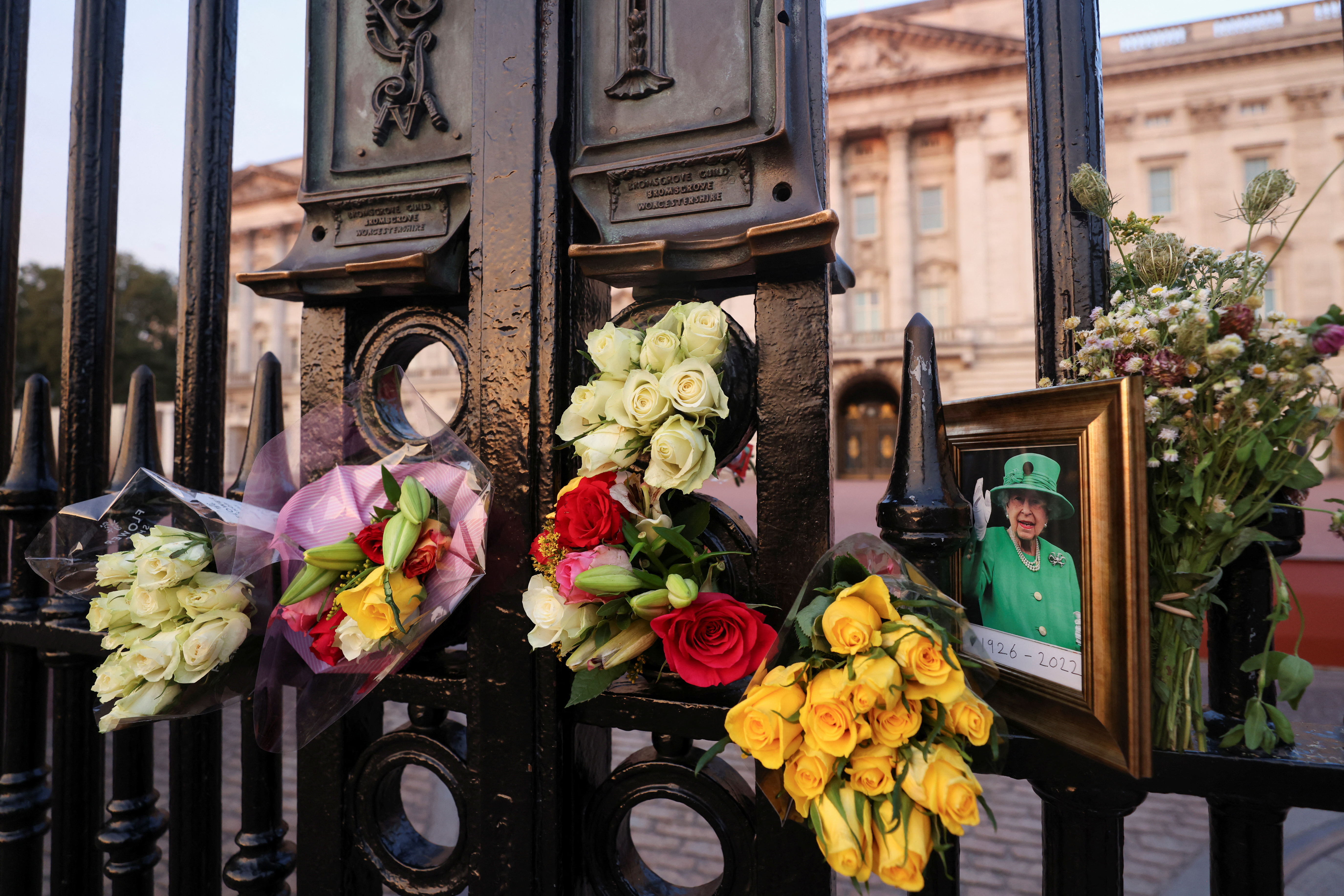 A picture and floral tributes laid outside Buckingham Palace are seen on the first anniversary of Queen Elizabeth II's death, in London, Britain
