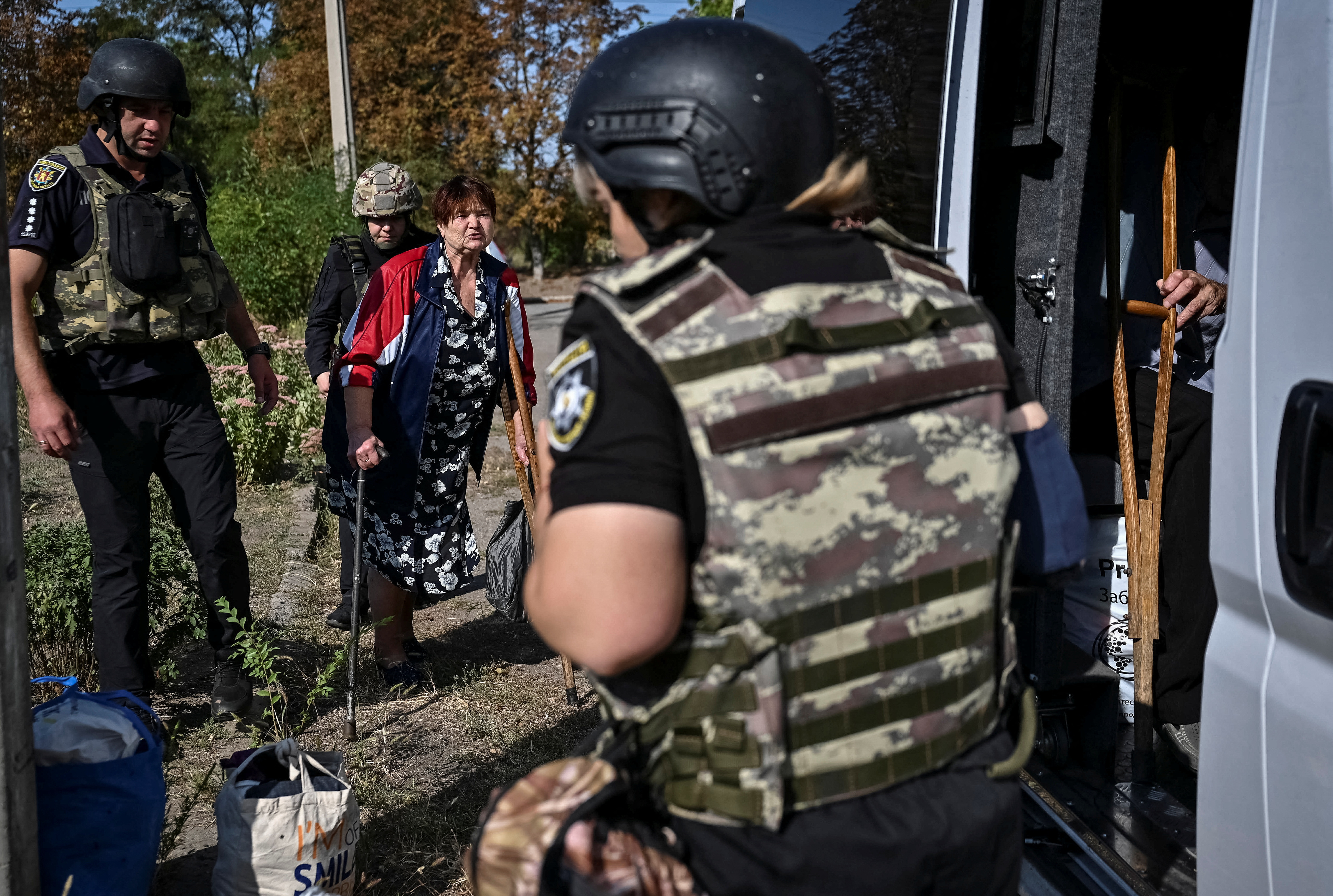 Police officers helping a resident living near the front line in the south to evacuate.