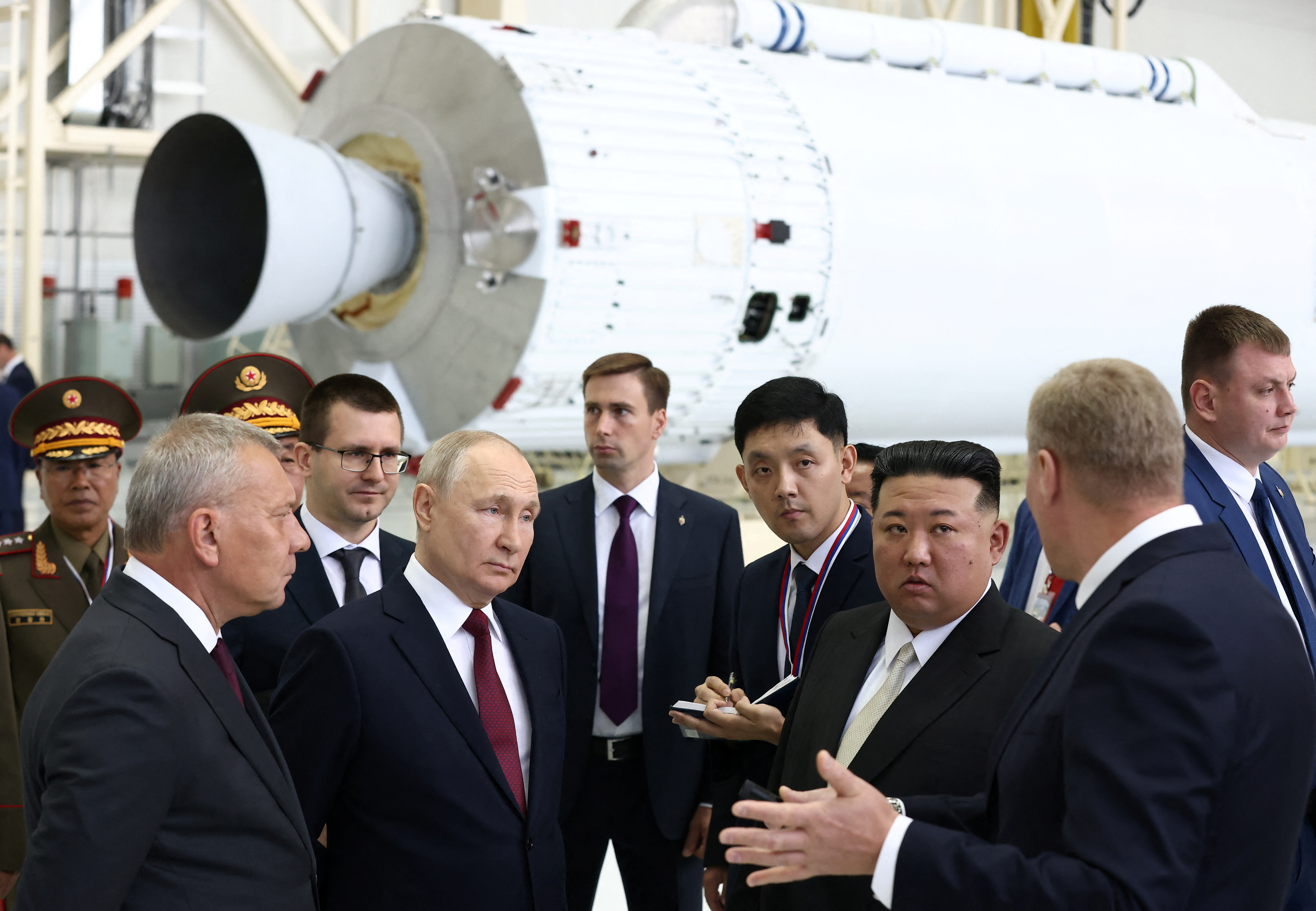 Putin and Kim touring the Vostochny Cosmodrome. Kim is listening to an official, Putin is watching.