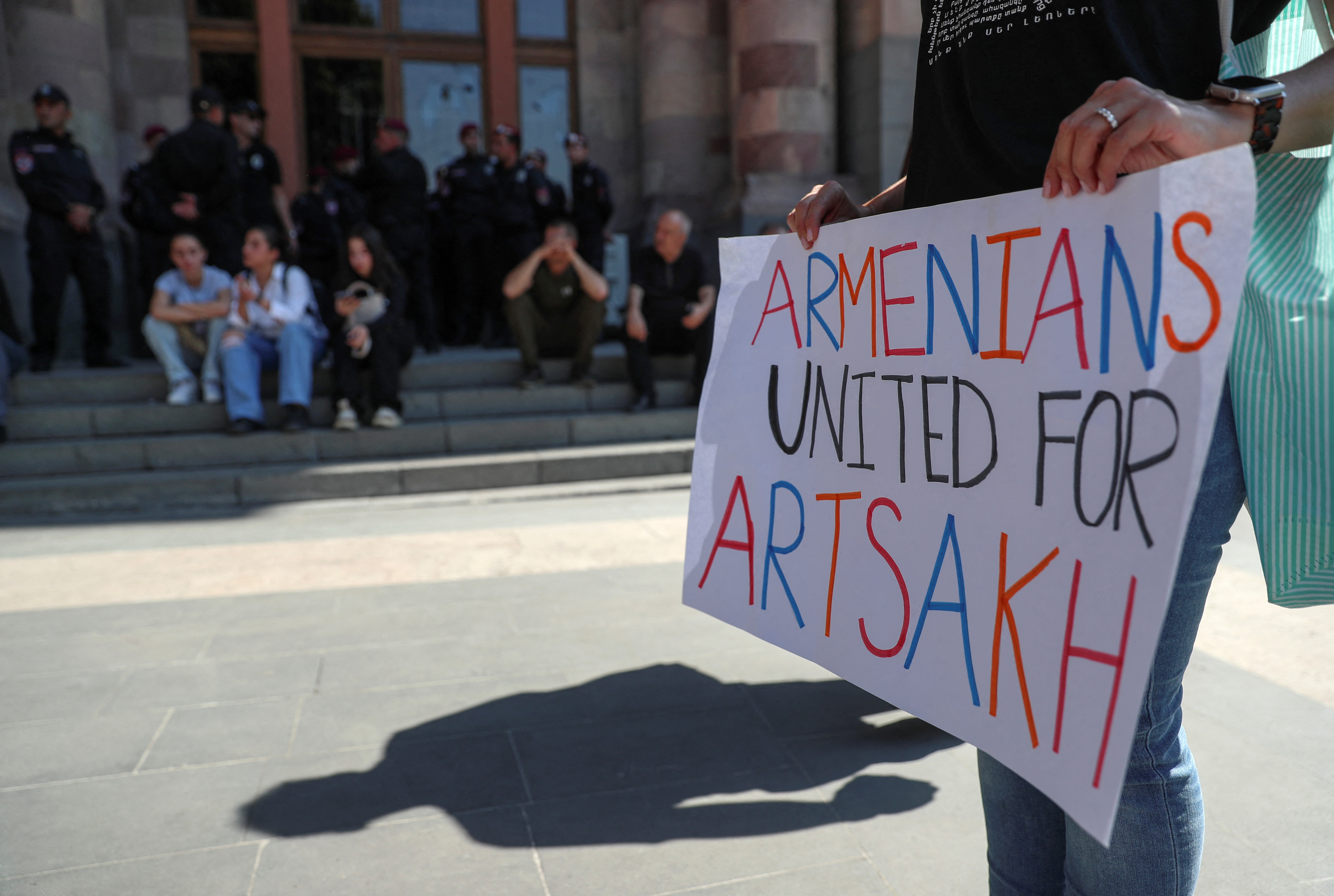 A protester holds a placard during a gathering outside the government building following the launch of a military operation by Azerbaijani forces in the region of Nagorno-Karabakh, in Yerevan, Armenia, September 20, 2023. REUTERS/Irakli Gedenidze