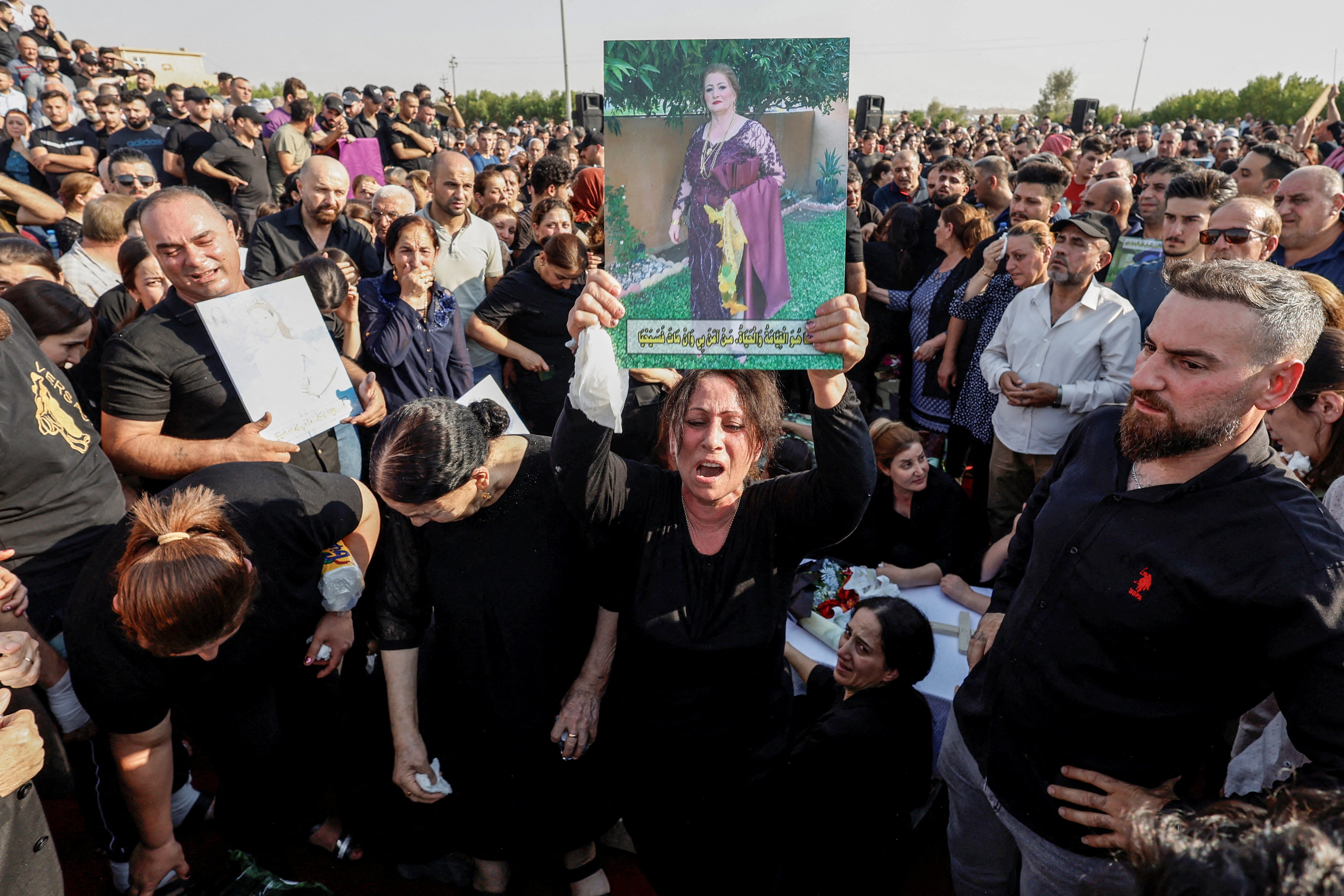 Mourners react during the funeral of victims of the fatal fire of a wedding celebration, in Hamdaniya, Iraq