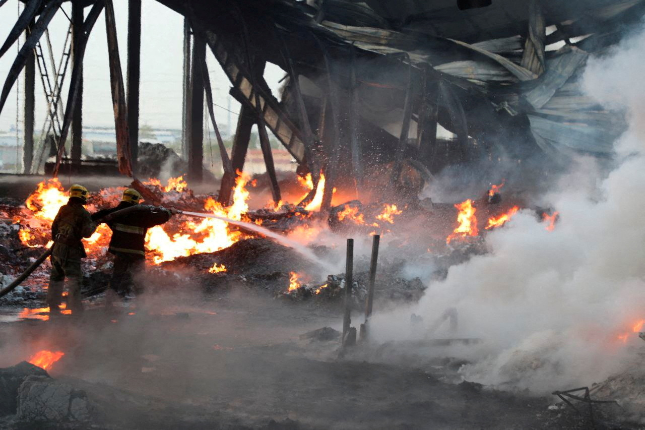 Specialists work to extinguish fire following an explosion at a warehouse near an airport in Tashkent, Uzbekistan
