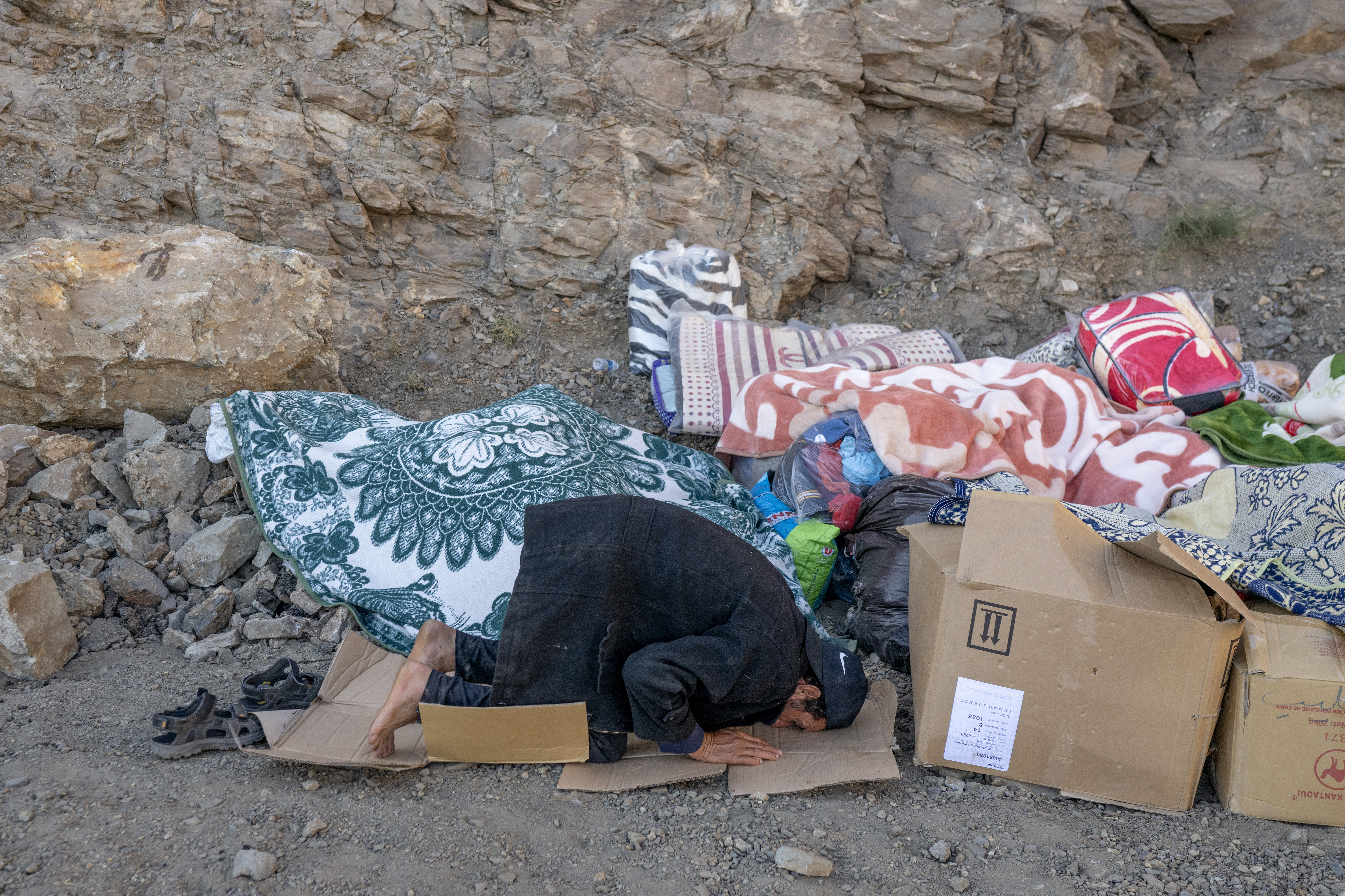 A man prays as he waits for emergency personnel to open a road to his village in the mountainous area of Tizi N'Test, in the Taroudant province