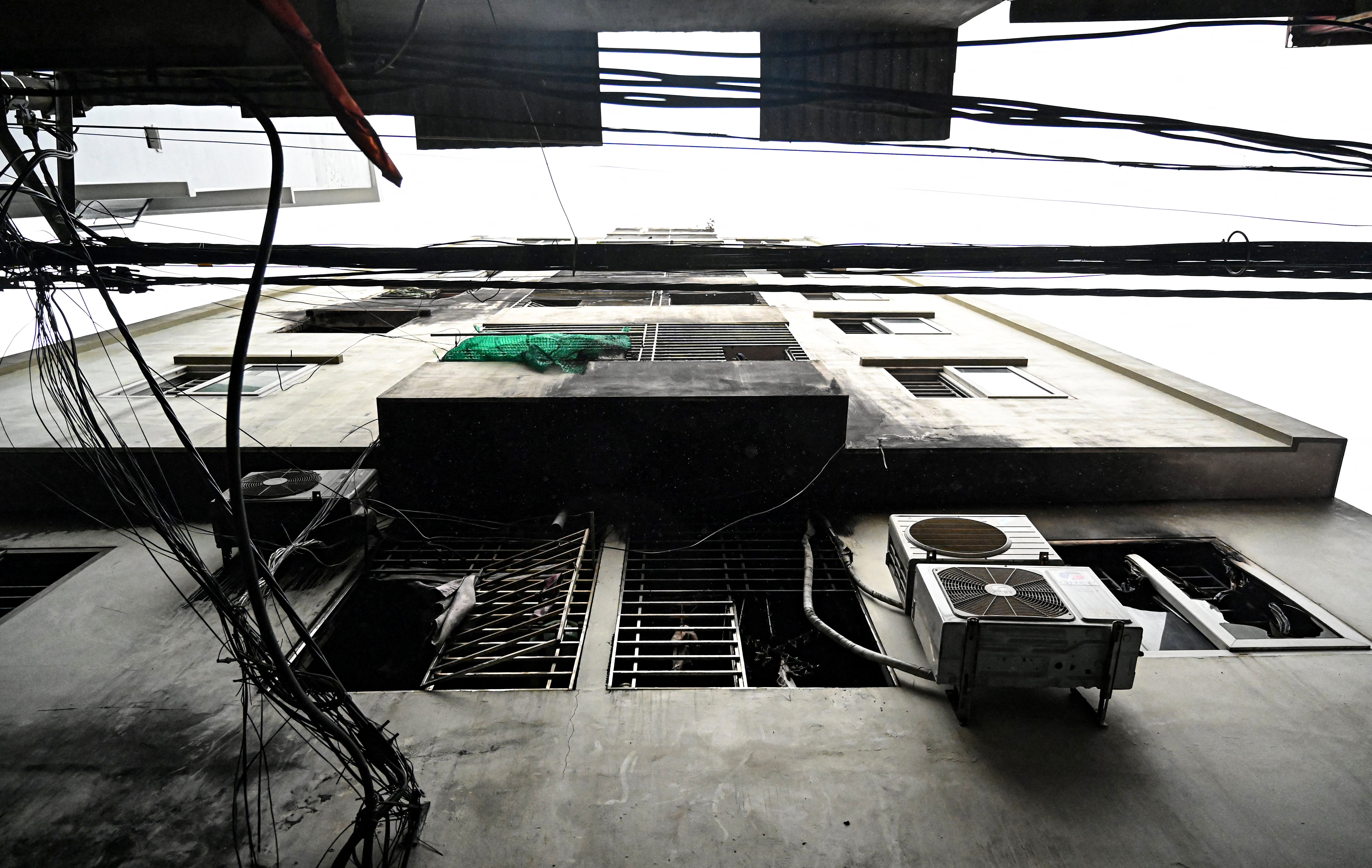 This picture shows windows damaged after a major fire at an apartment block in Hanoi on September 13, 2023