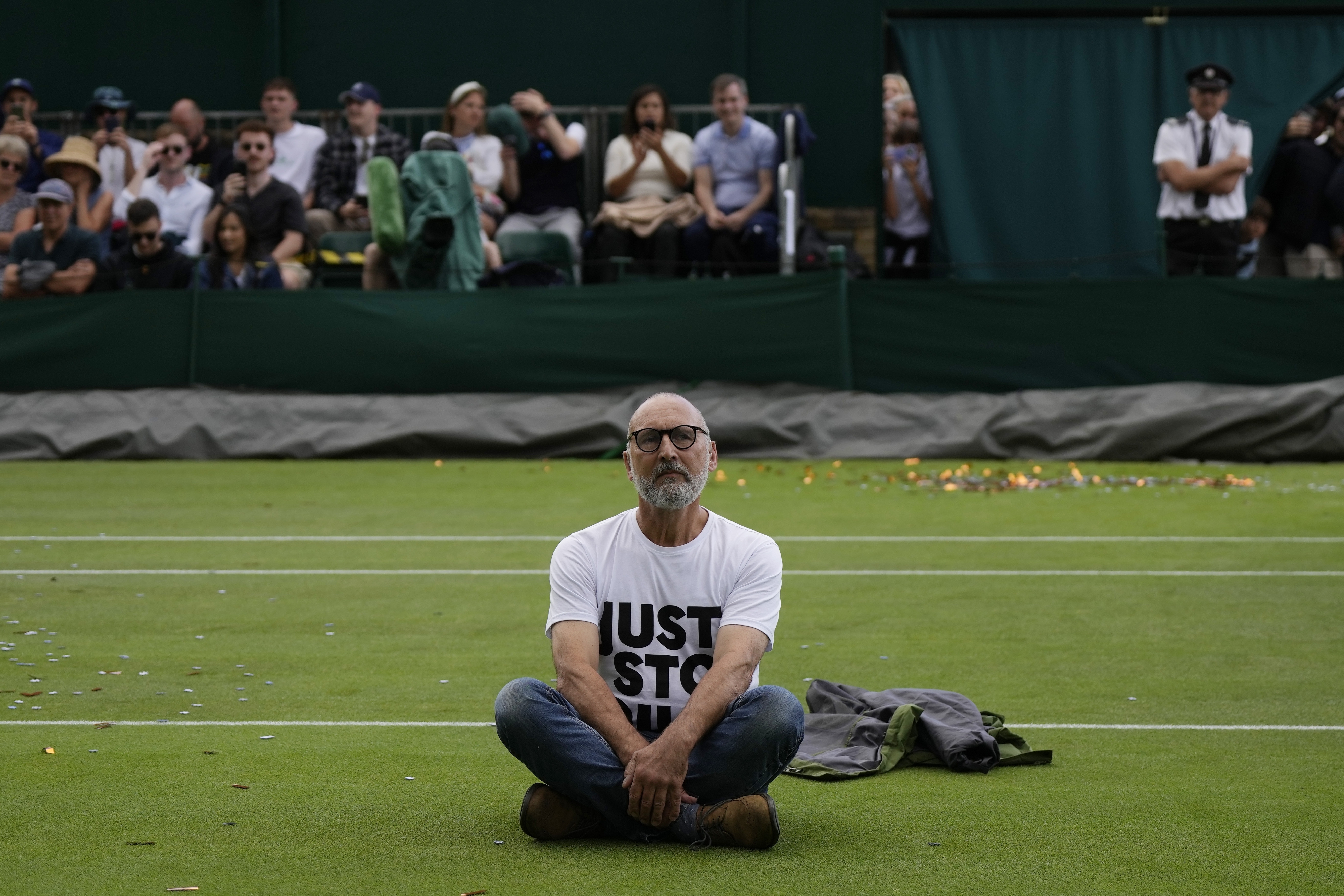 A Just Stop Oil protester sits on Court 18 on day three of the Wimbledon tennis championships