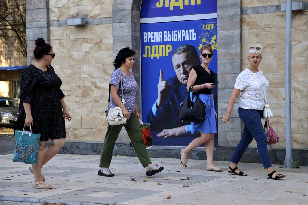 People walk past a Russian Liberal Democratic Party poster in Donetsk