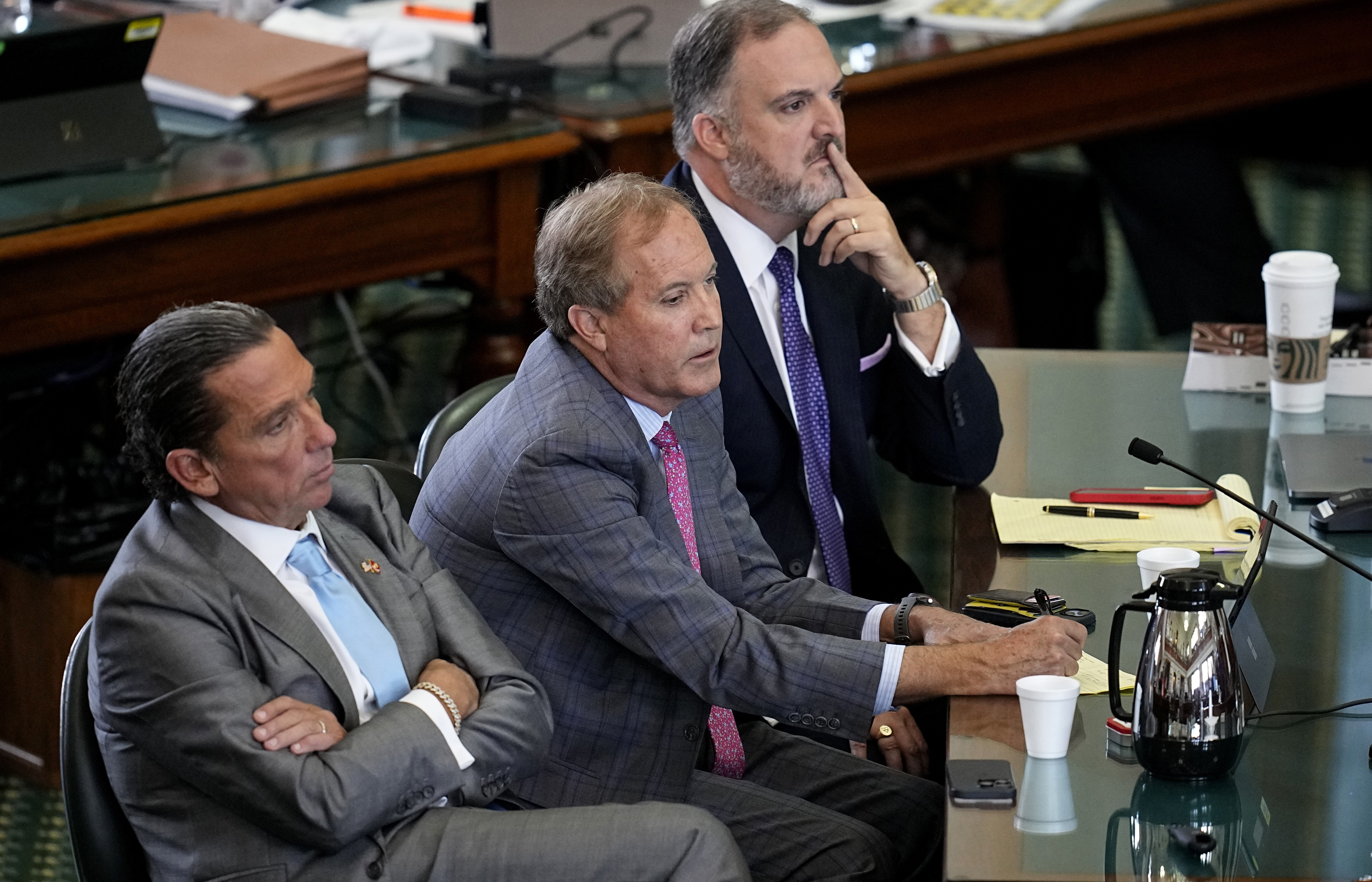 Texas state Attorney General Ken Paxton sits with his attorneys Tony Buzbee and Mitch Little as his impeachment trial continues in the Senate Chamber at the Texas Capitol