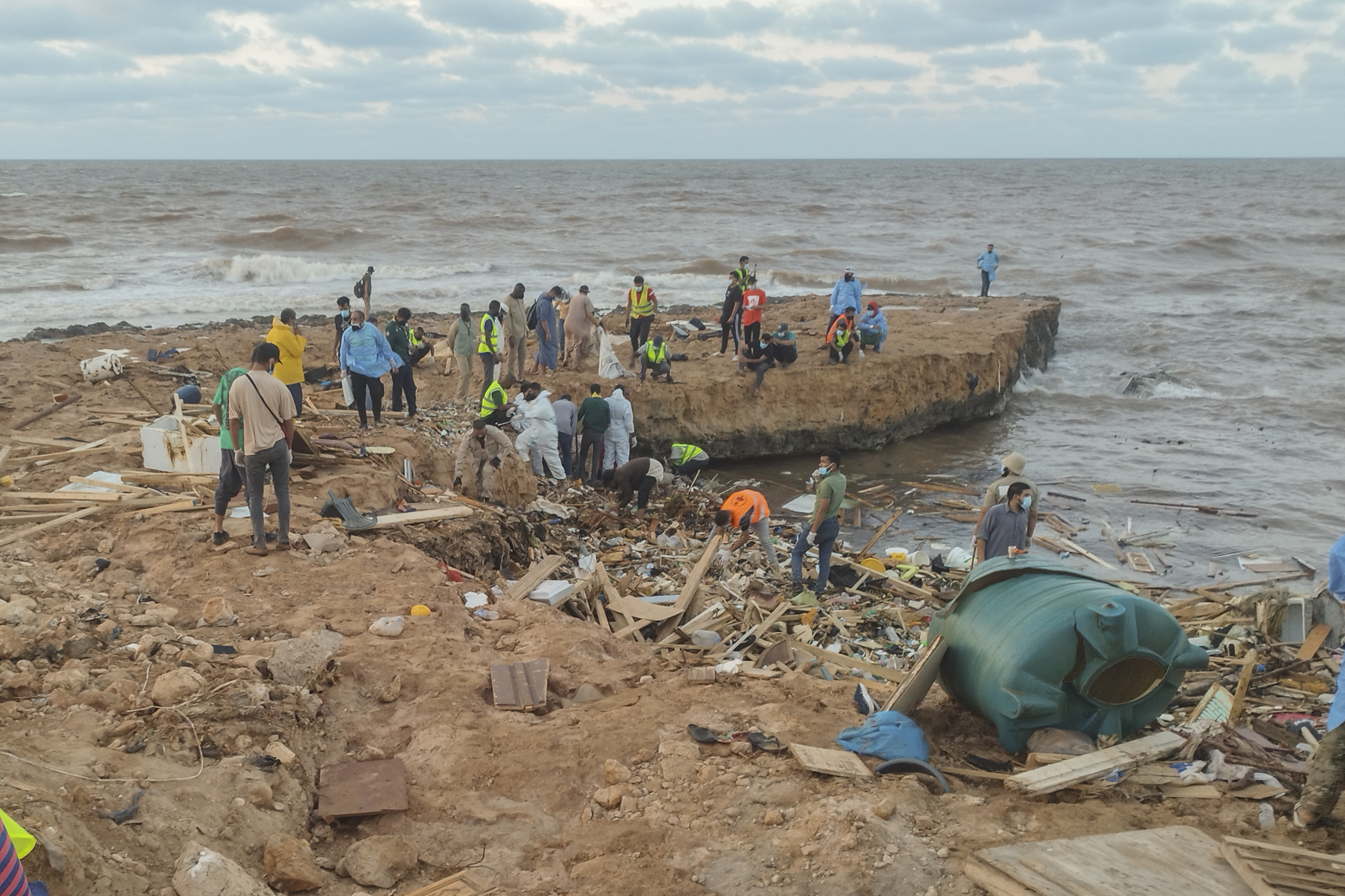 Rescuers and relatives search for bodies of the flood victims at the Corniche of the city of Derna