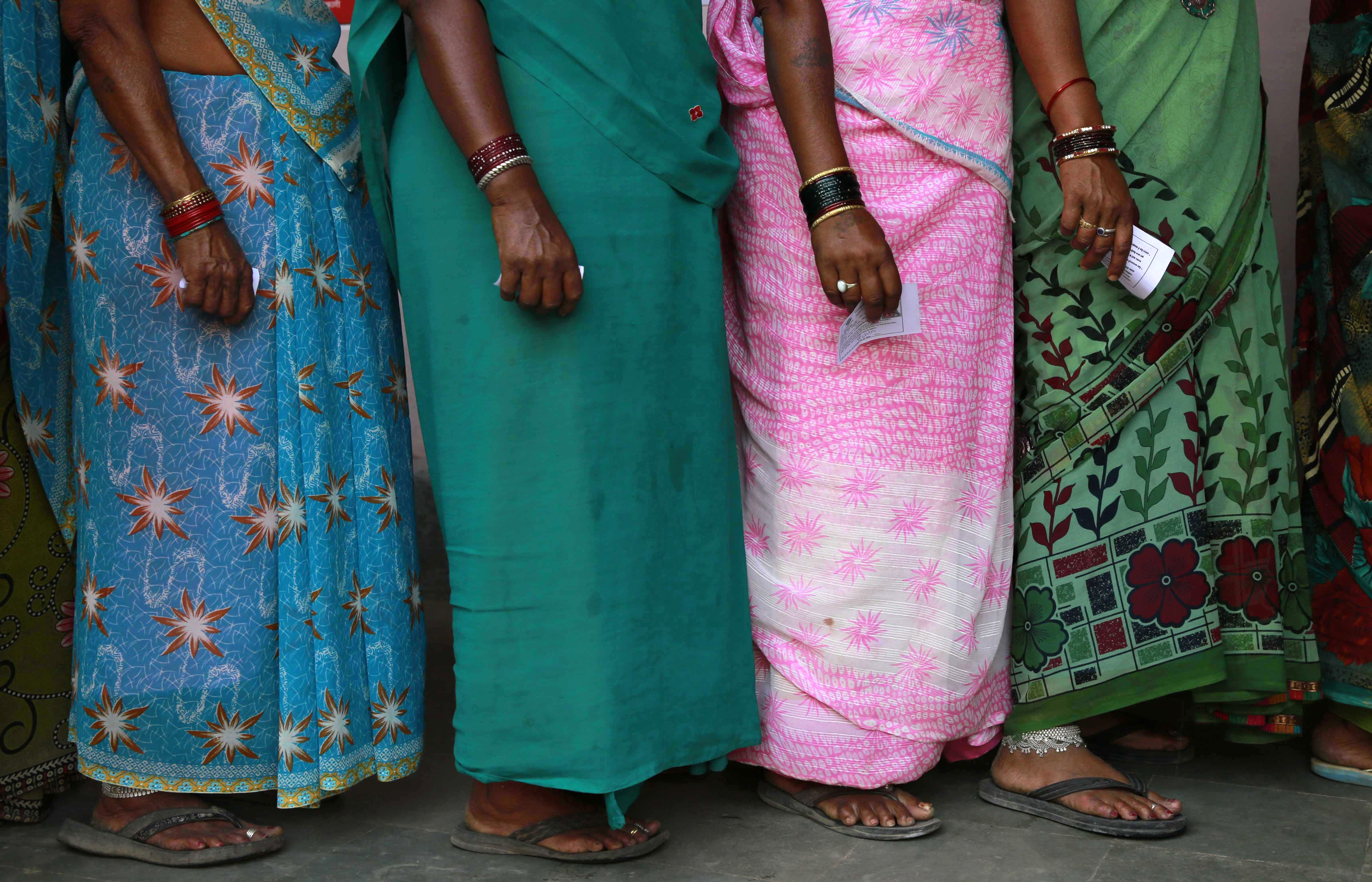 women wait to vote in India