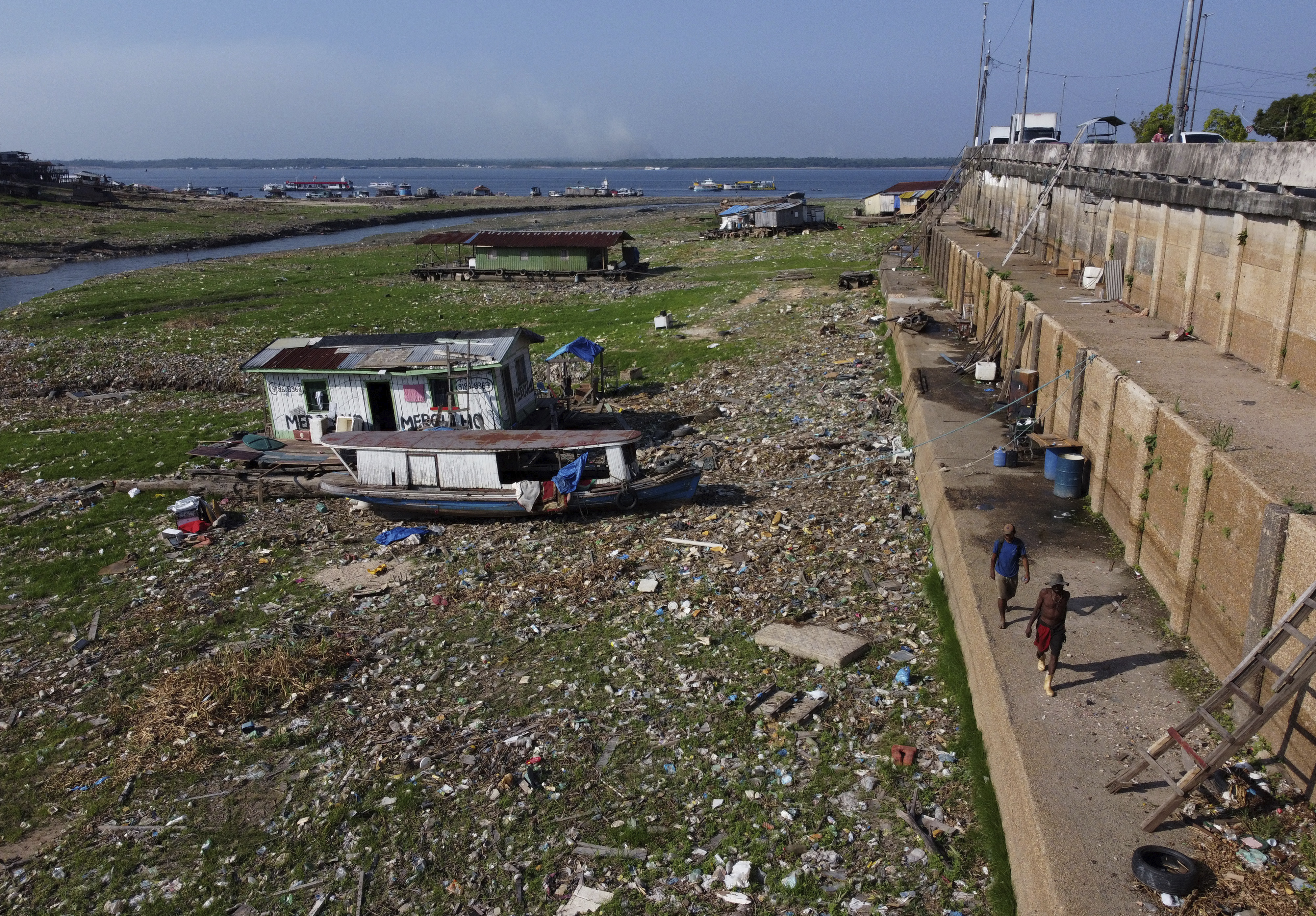 Houseboats, boats and trash lay on the now dry area that used to be covered by the Negro river