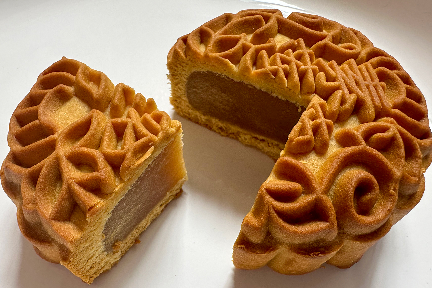 A close-up of a mooncake. It has been cut open to show the inside