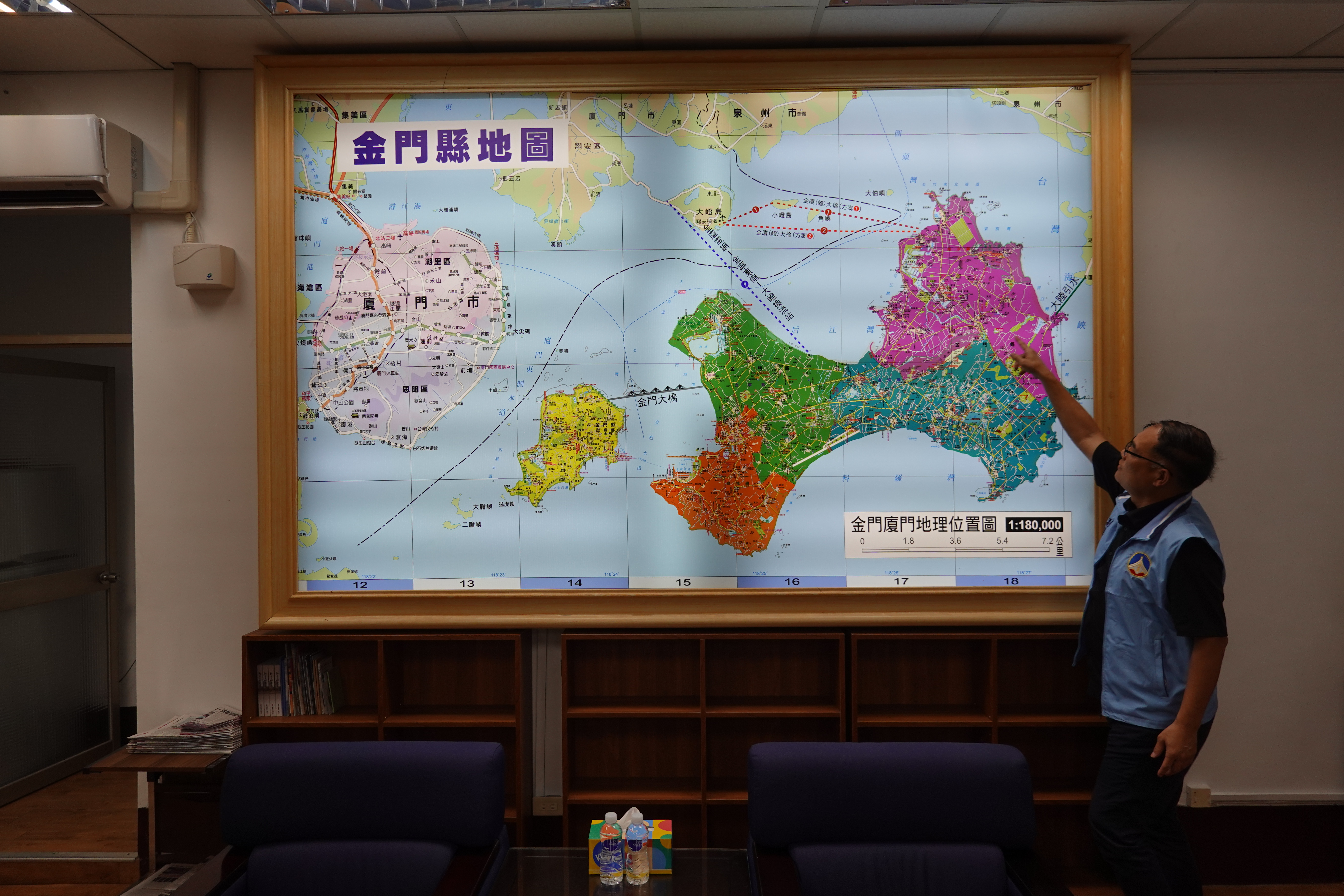 A photo of Li Wen-Liang pointing towards a map of Kinmen.