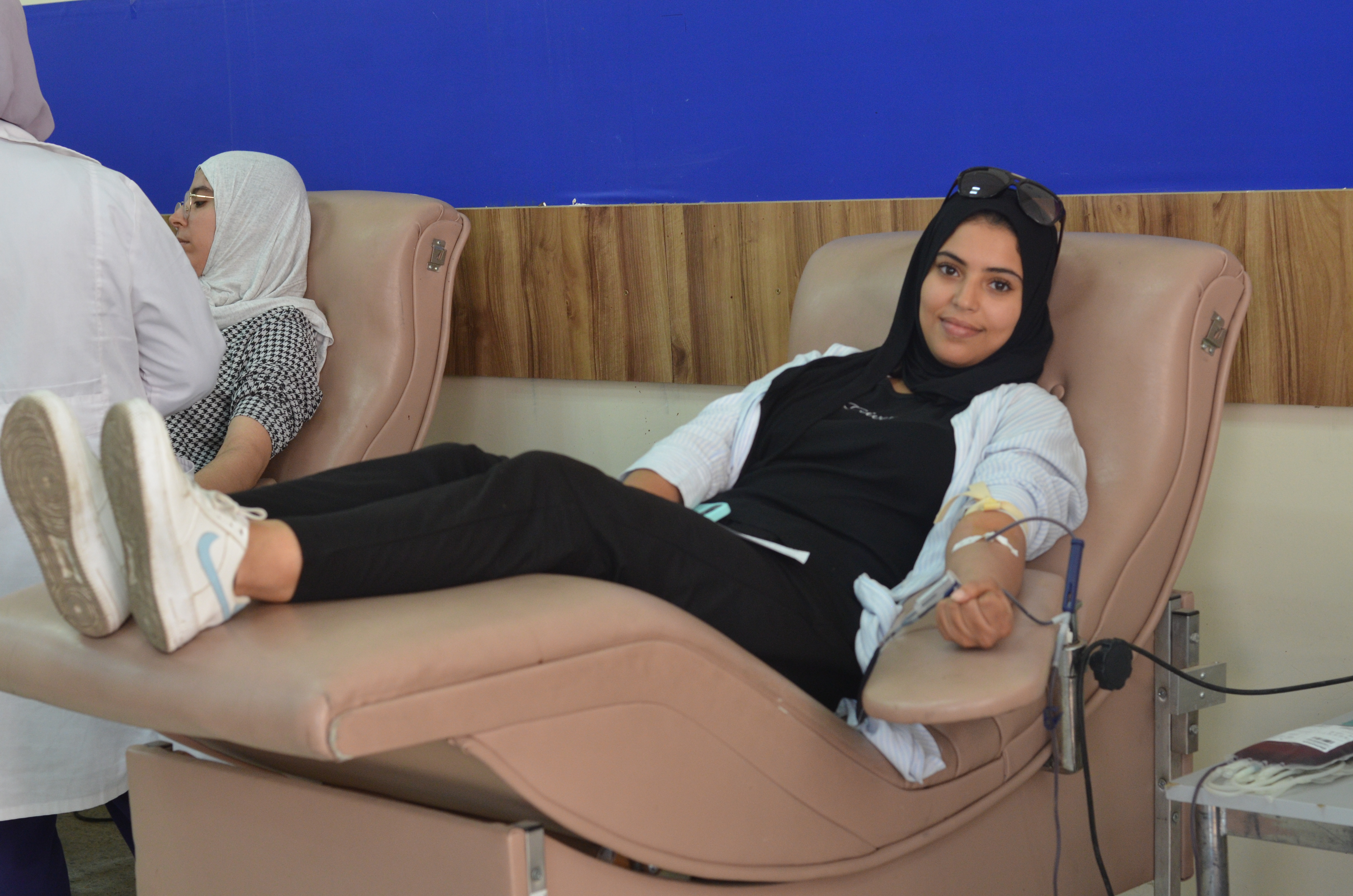 woman lies down as she donates blood