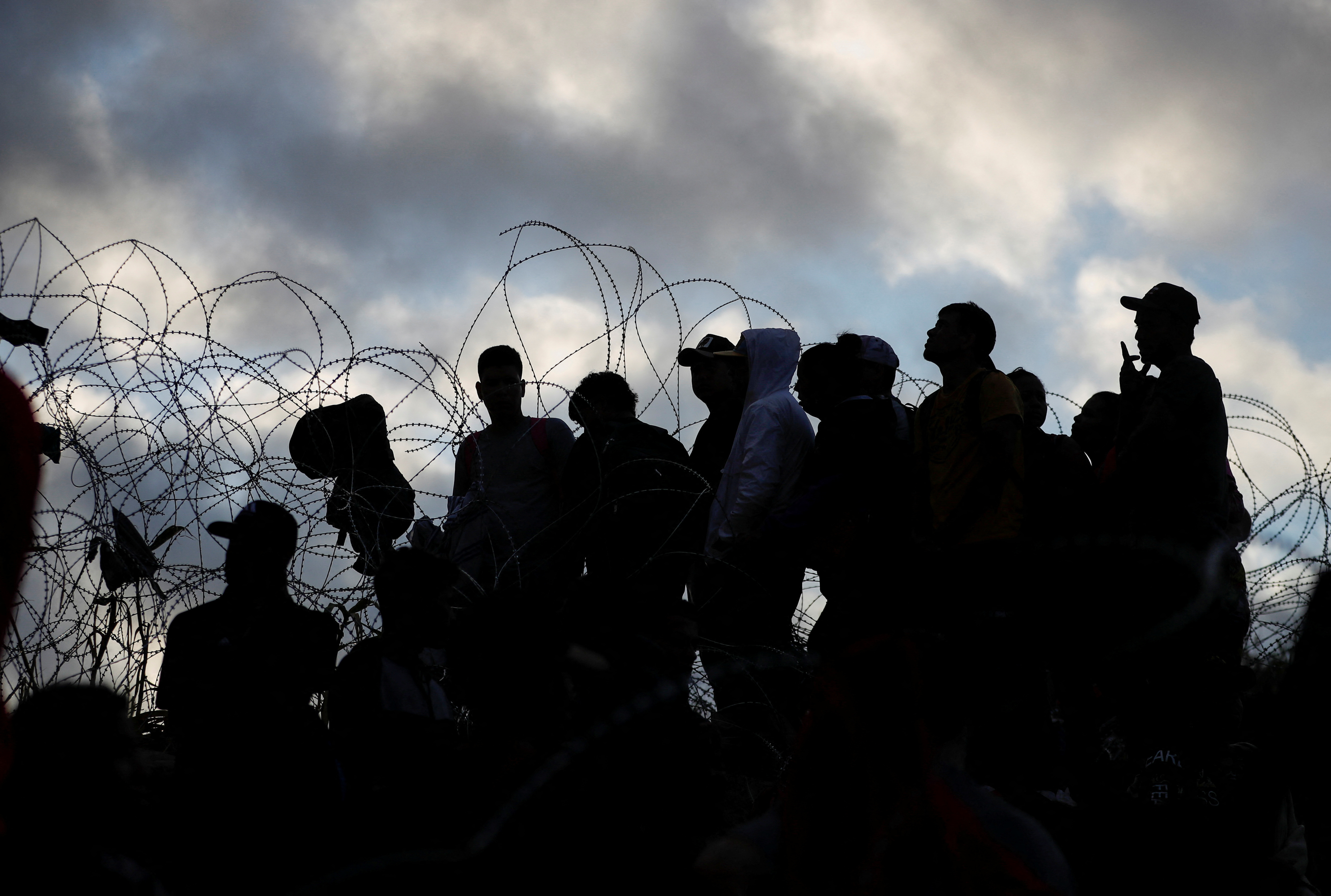 Migrants wait on the banks of the Rio Grande river in an attempt to seek asylum into the U. S., as seen from Piedras Negras, Mexico September 30, 2023
