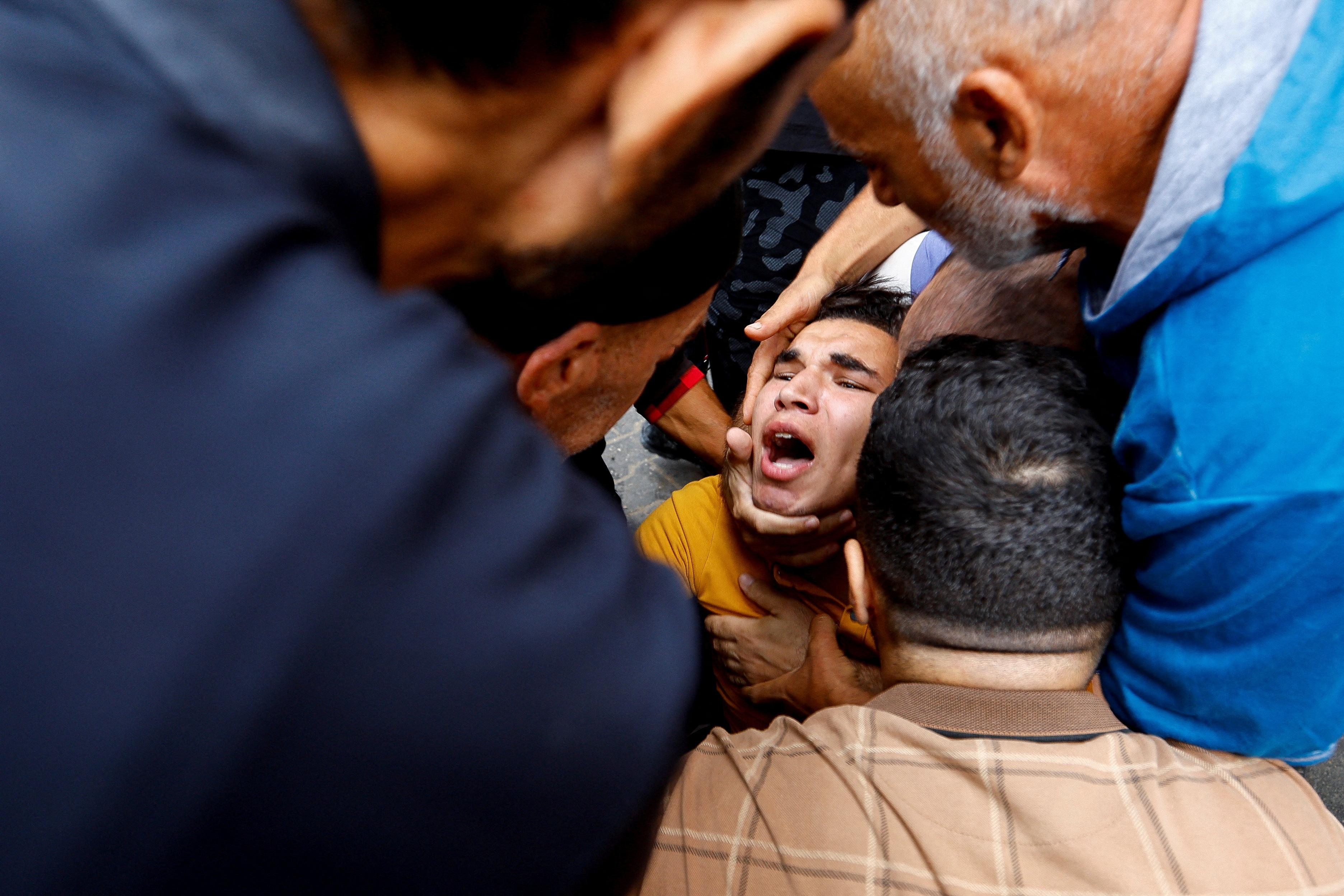 A relative reacts as Palestinians carry casualties from under the rubble of a house destroyed in Israeli strikes, in Rafah in the southern Gaza Strip