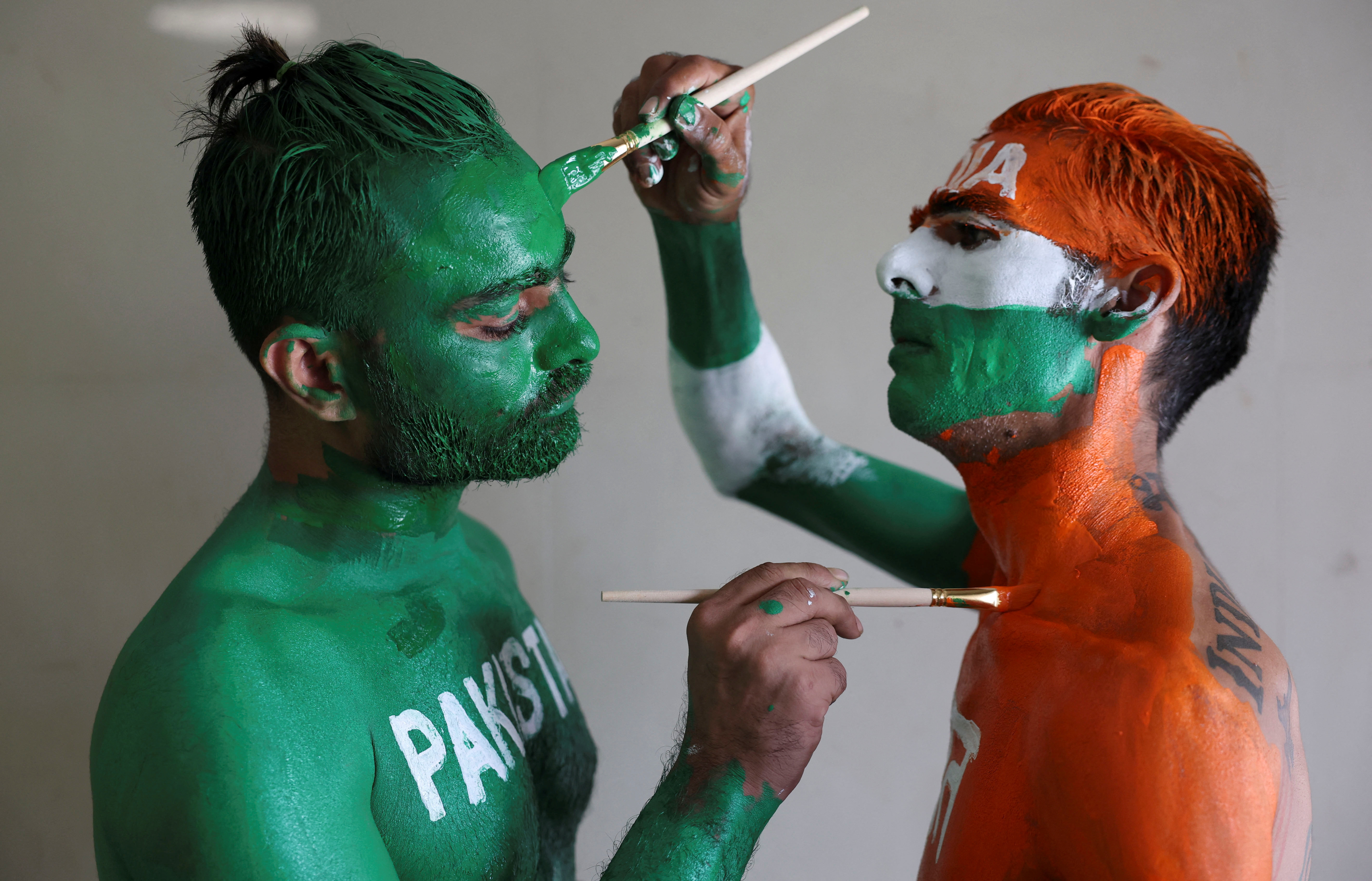 Cricket fans, Arun Haryani (Right) and Anil Advani (Left) paint their bodies in the Indian and Pakistani national flag colours