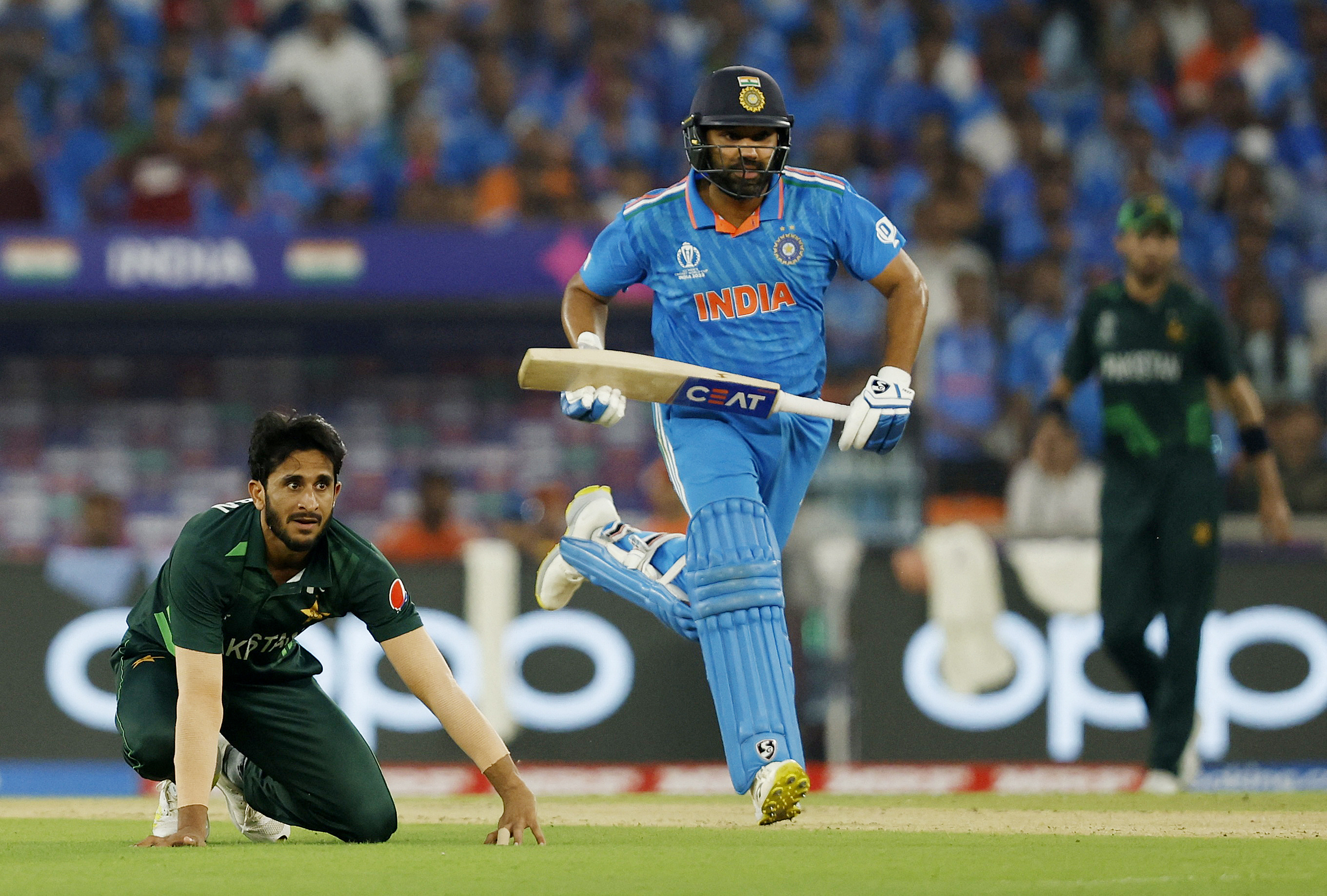India's Rohit Sharma runs between the wickets as Pakistan's Hasan Ali looks on