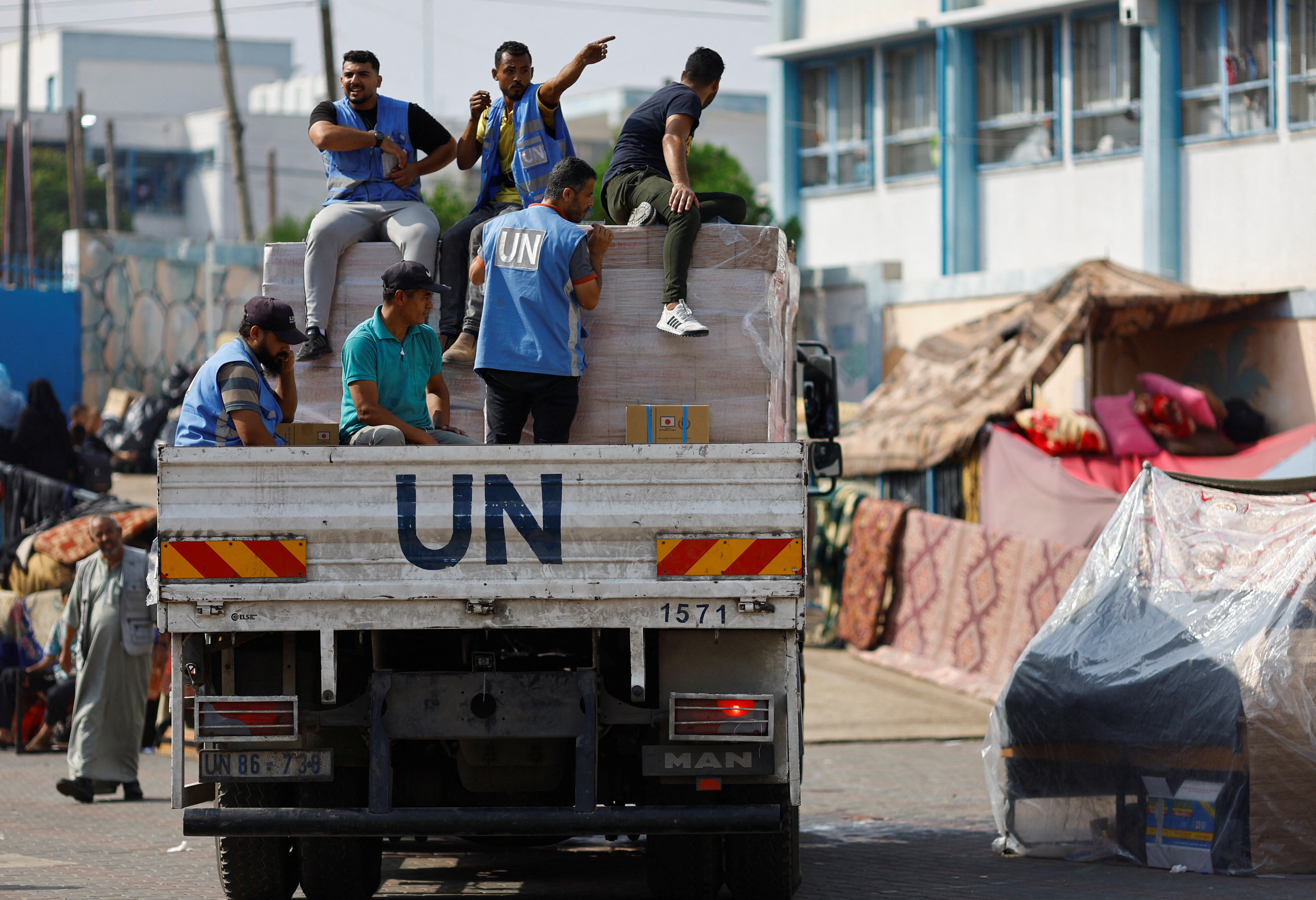 United Nations workers arrive to distribute aid to Palestinians, who have fled their homes due to Israeli strikes and take shelter in a UN-run school, in Khan Younis in the southern Gaza Strip October 23, 2023. REUTERS/Mohammed Salem