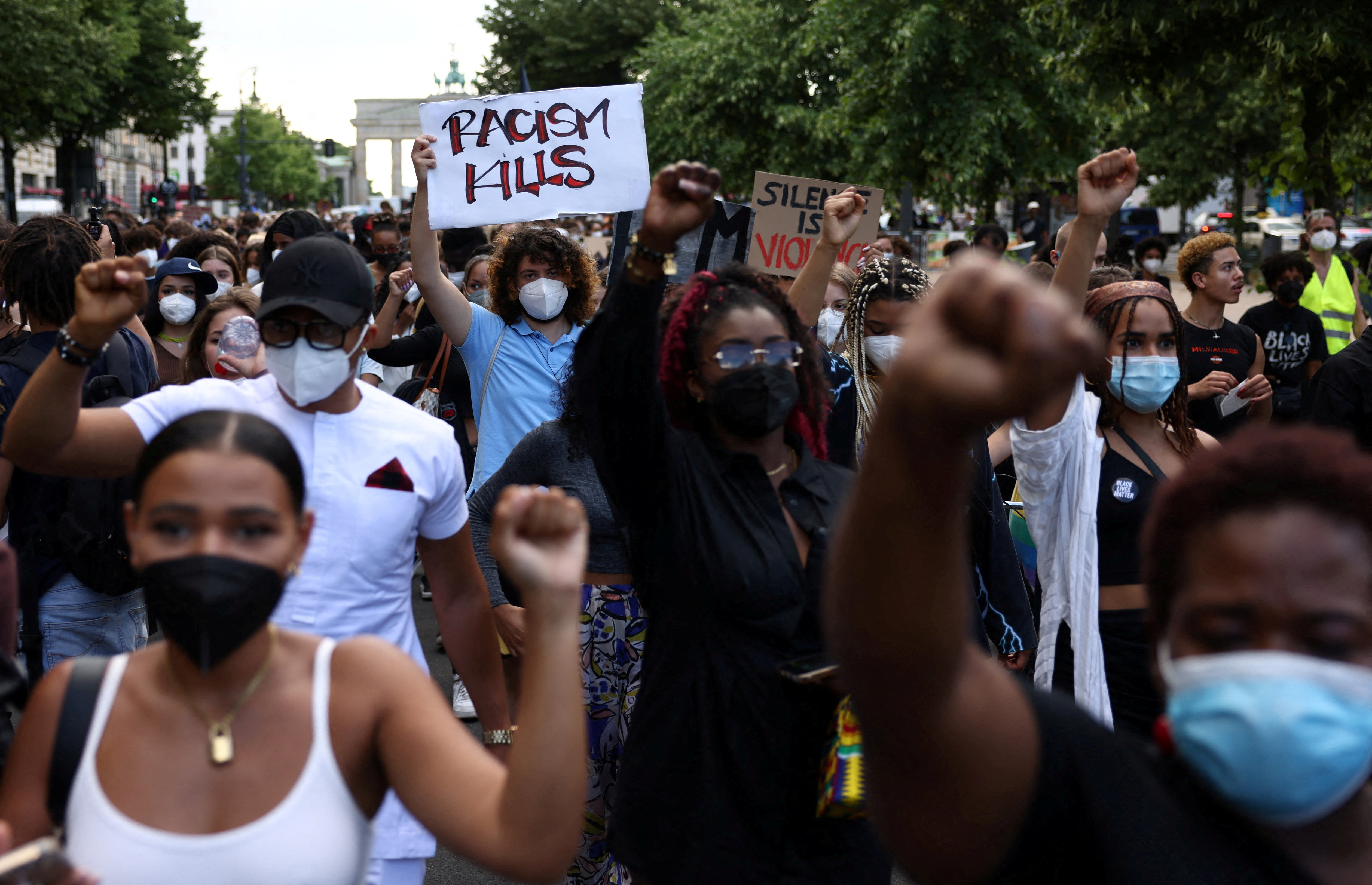 FILE PHOTO: A demonstrator holds a placard reading "Racism Kills" during a Black Lives Matter protest in Berlin, Germany, July 2, 2021. REUTERS/Christian Mang/File Photo