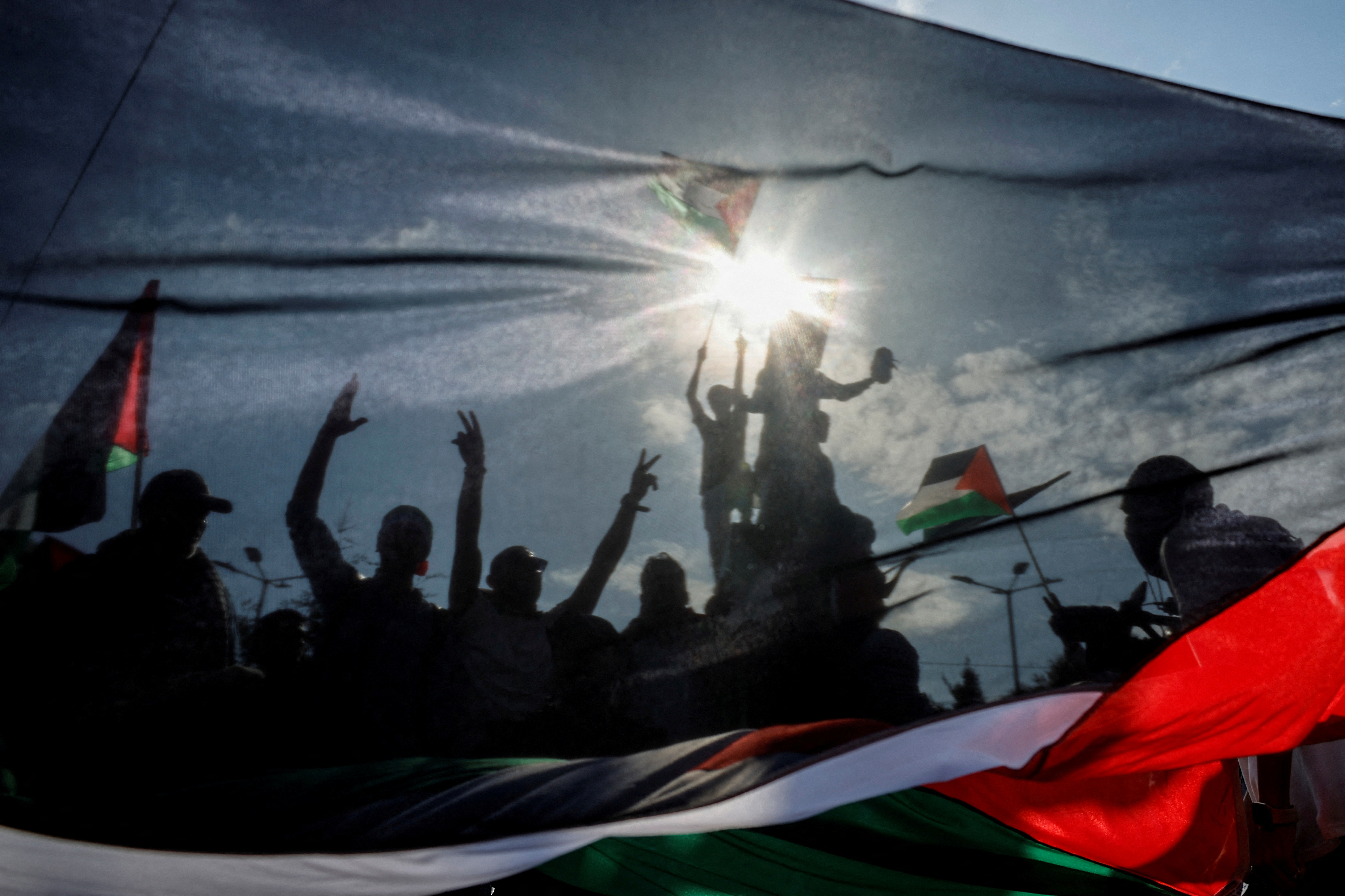 Protesters shout slogans behind a Palestinian flag outside the Israeli embassy, during a pro-Palestinian protest in Athens, Greece