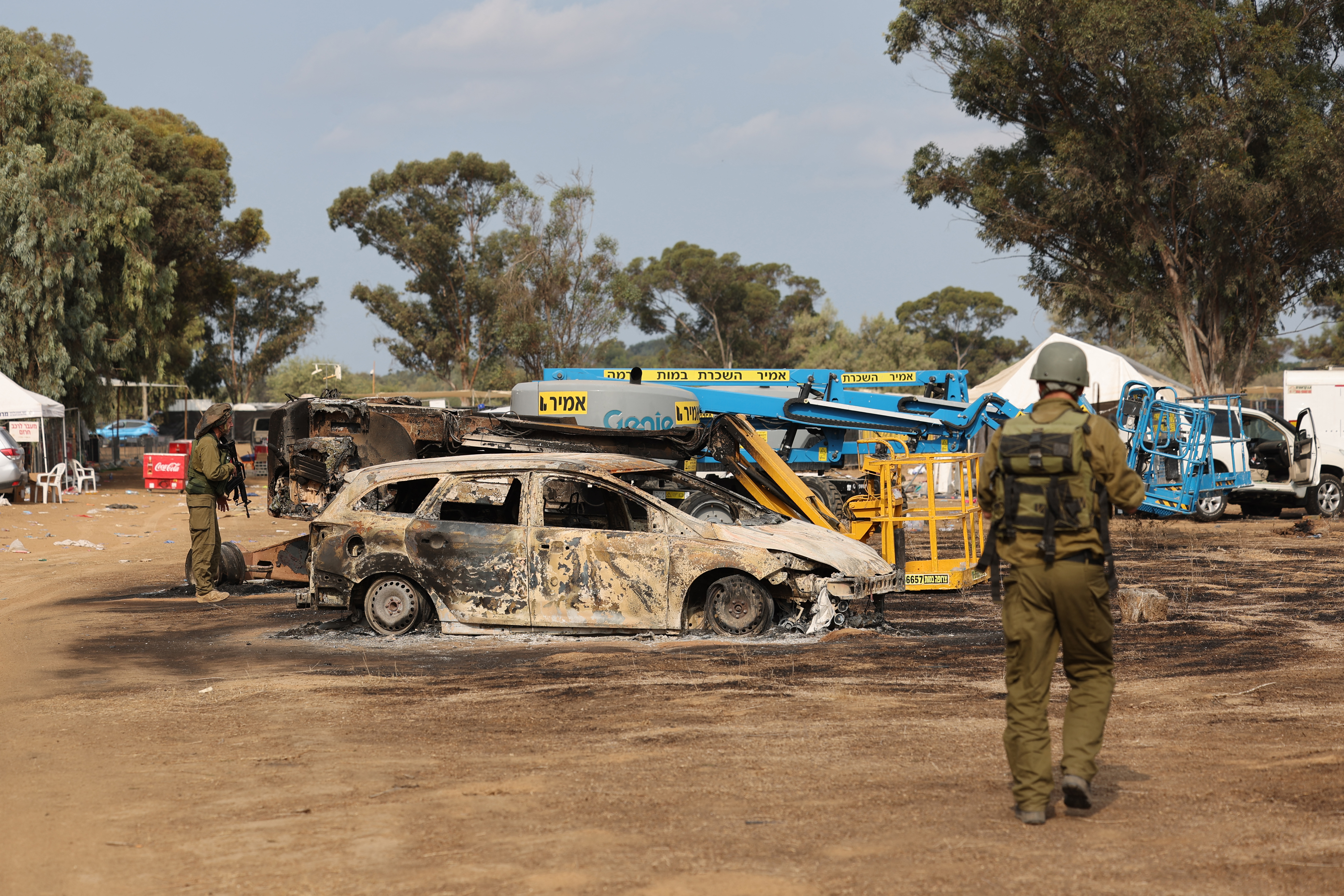 Israeli troops inspect the ravaged site of the weekend attack on the Supernova desert music Festival 