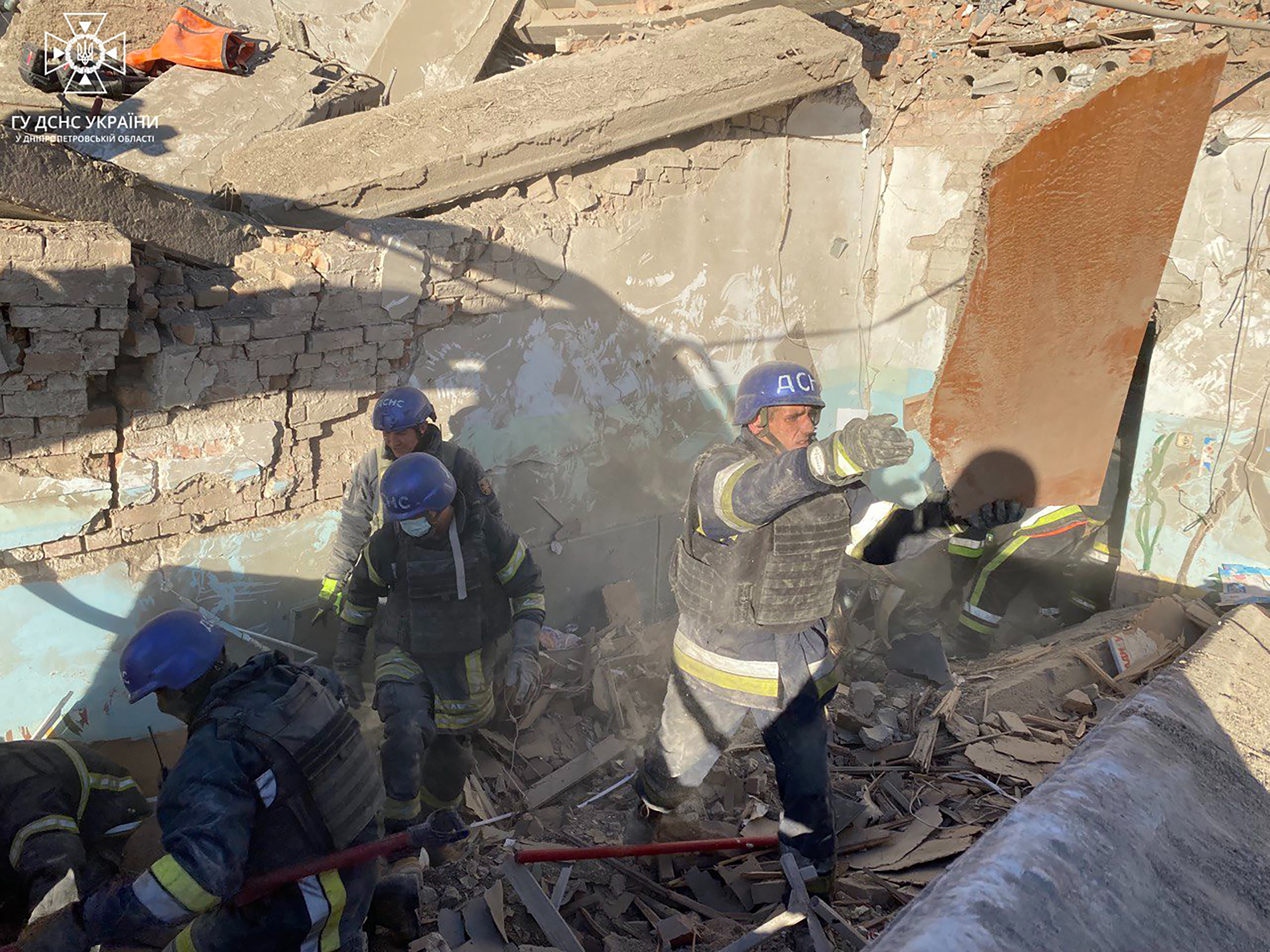 Rescue teams in the rubble of a Ukrainian school hit by a Russian missile