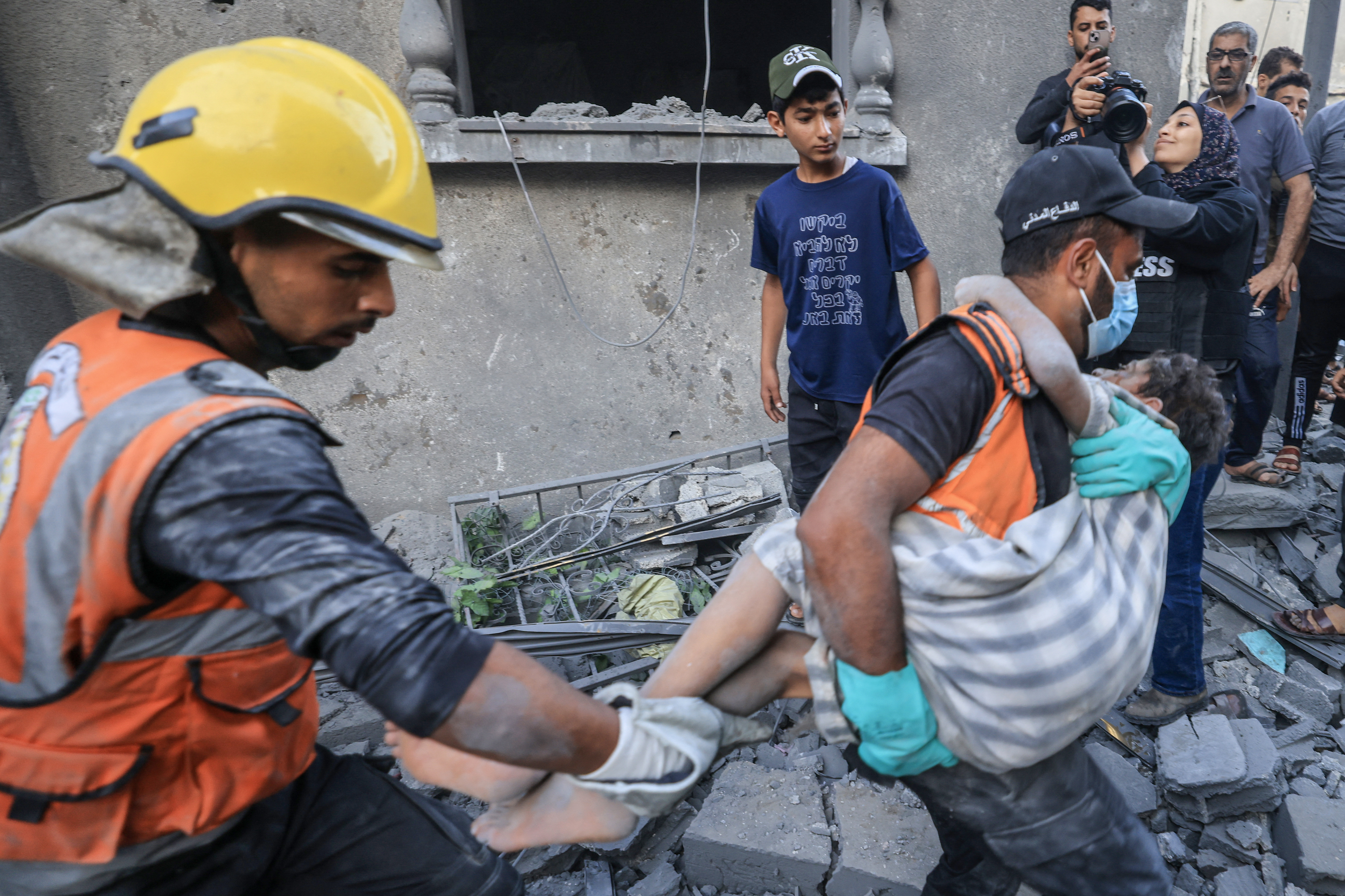 Palestinians civil look for survivors in the rubble of a building hit during Israeli bombardment in Khan Yunis