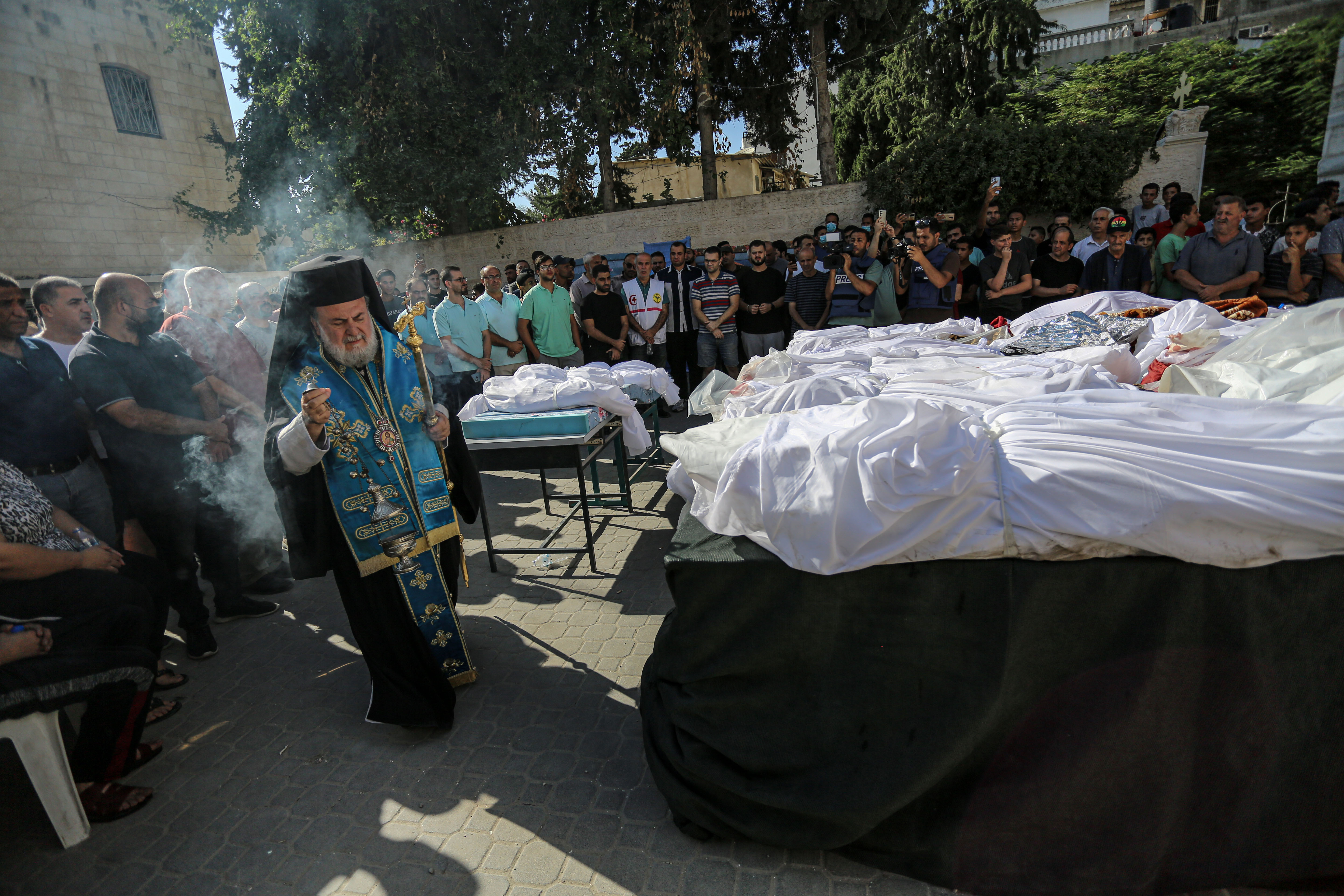 Archbishop Alexios of Tiberias visits Saint Porphyrius Orthodox church in Gaza City, which was severely damaged in an Israeli airstrike on Thursday. At least 18 people were killed [Abdelhakim Abu Riash/Al Jazeera]