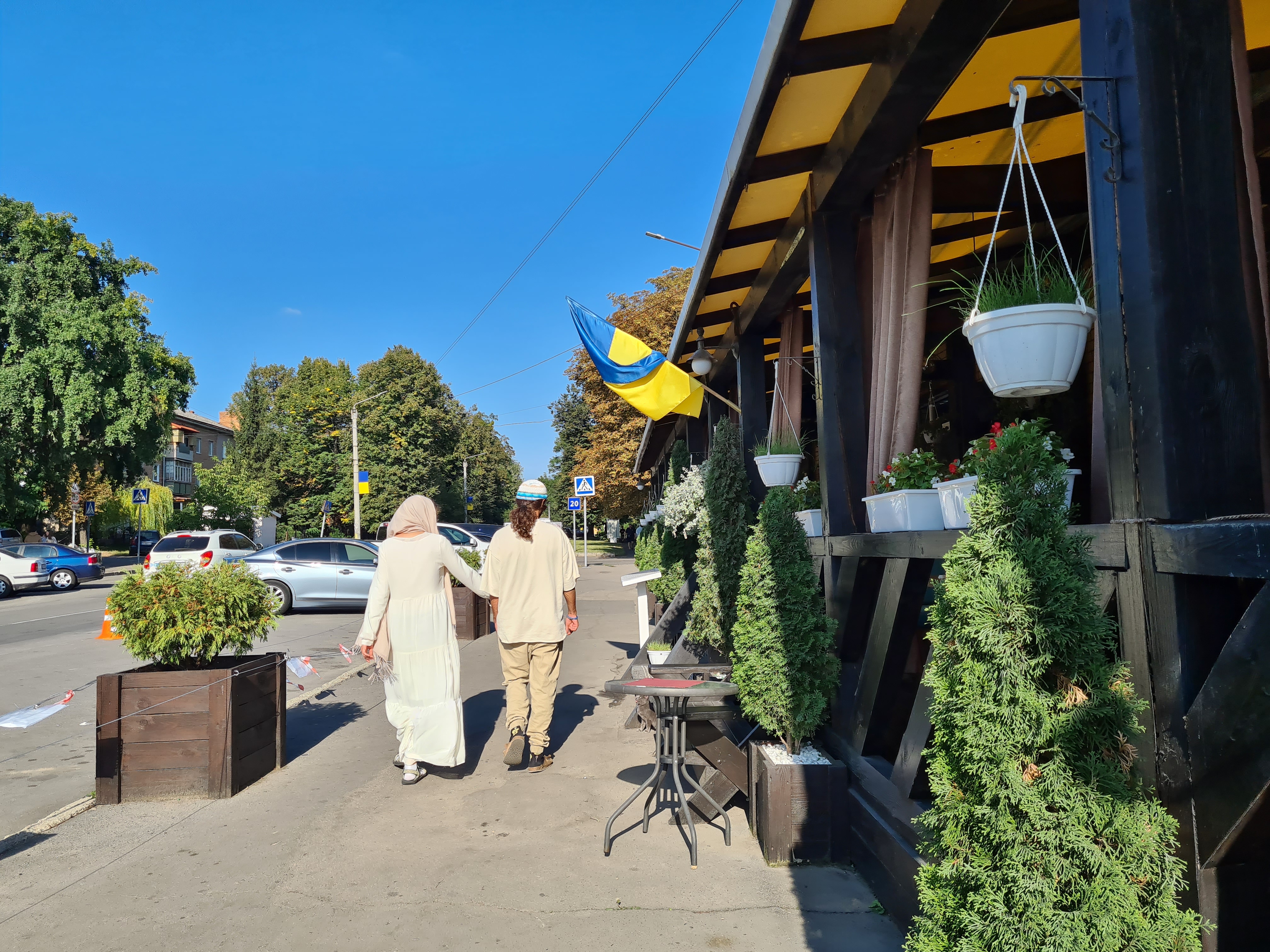 A Hasidic Jewish couple walking under a Ukrainian flag during their pilgrimage to Uman on Sept. 17-1696946886