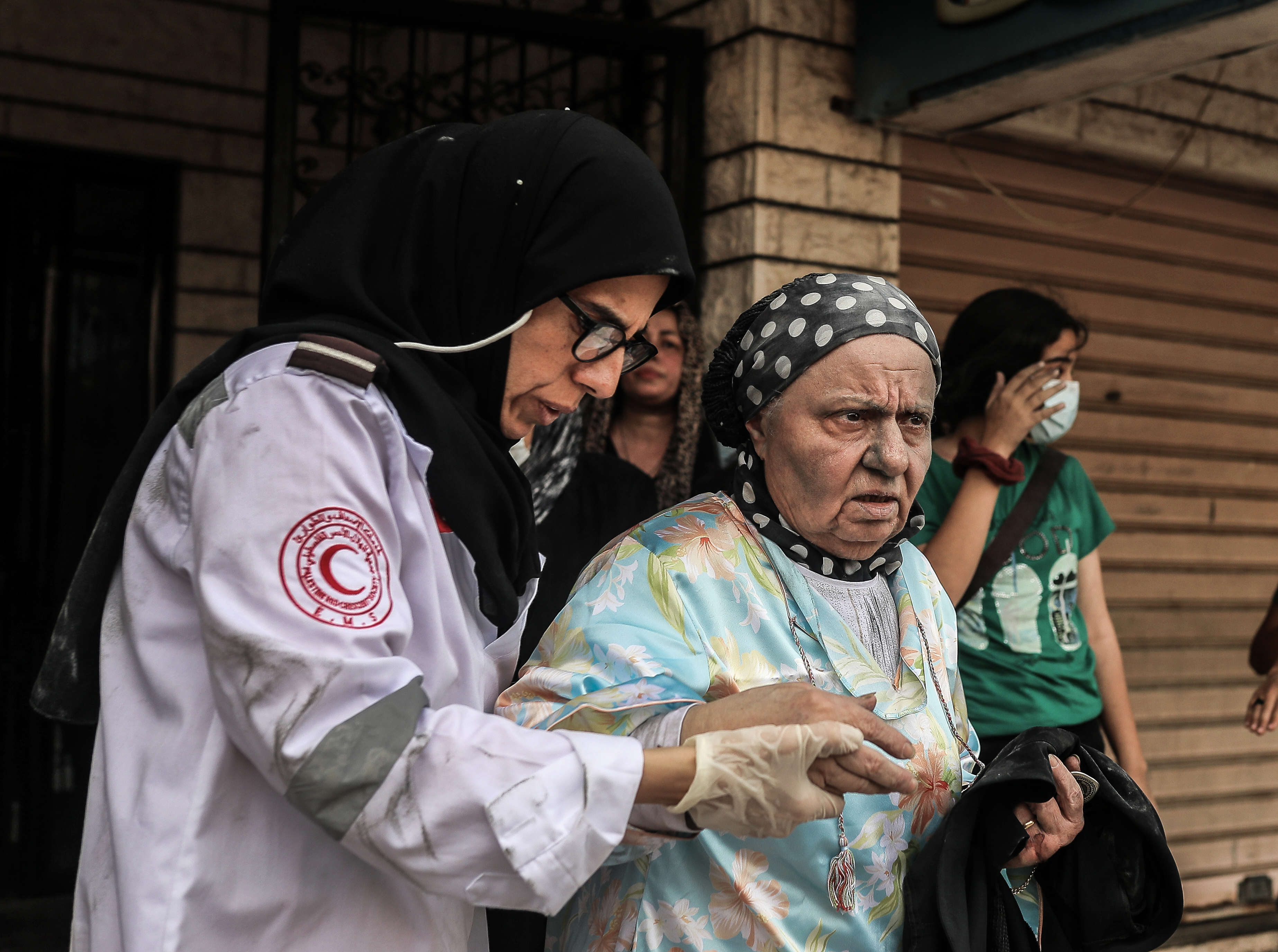 Palestinians rescued from the rubble are being taken to ambulances after Israeli air raids destroyed buildings in Gaza City, October 9, 2023