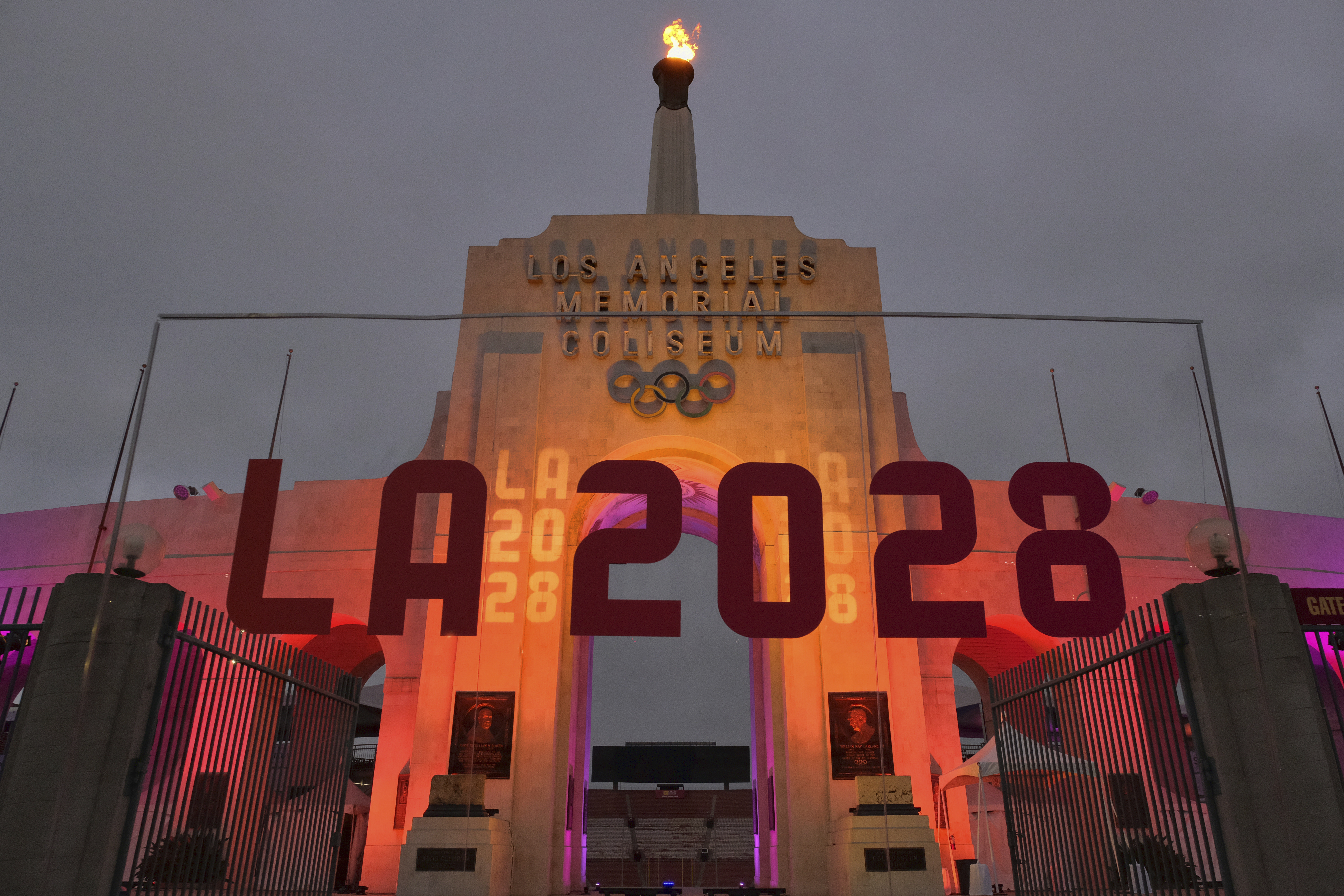 An LA2028 sign is seen in front of a blazing Olympic cauldron at the Los Angeles Memorial Coliseum on Wednesday, Sept. 13, 2017. The cauldron was lit early Wednesday morning at the stadium that was the site of the 1932 and 1984 Olympics. An International Olympic Committee meeting in Peru is to make it official that LA will host in 2028 and that the 2024 Games will go to Paris. (AP Photo/Richard Vogel)