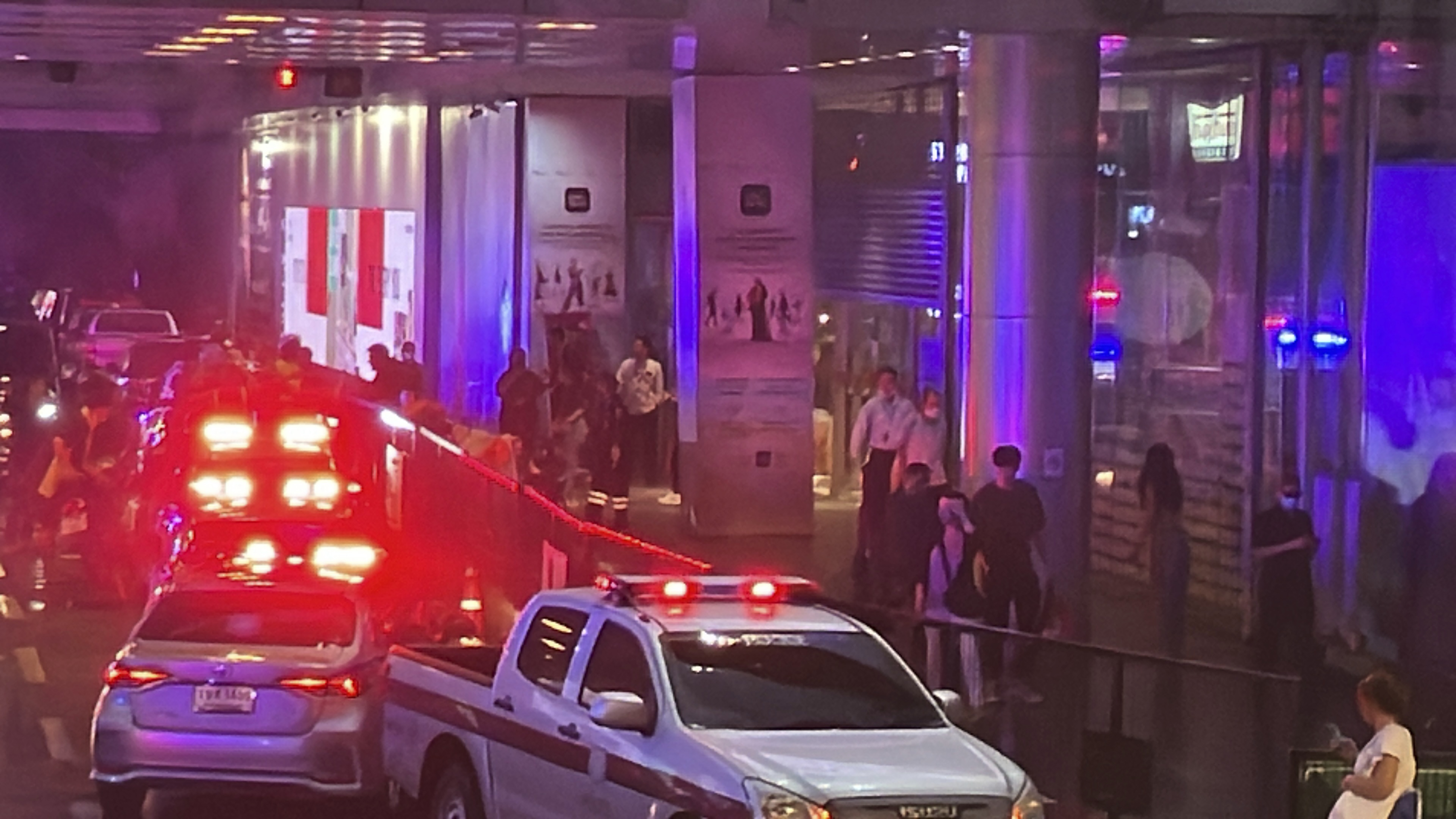 Ambulances wait outside an exit of the Siam Paragon Mall in Bangkok